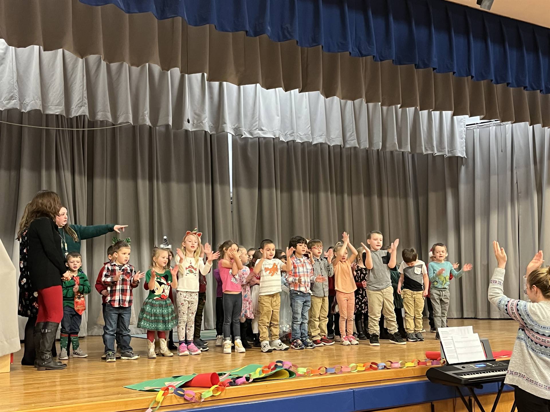 a large group of students on stage with gray curtain background