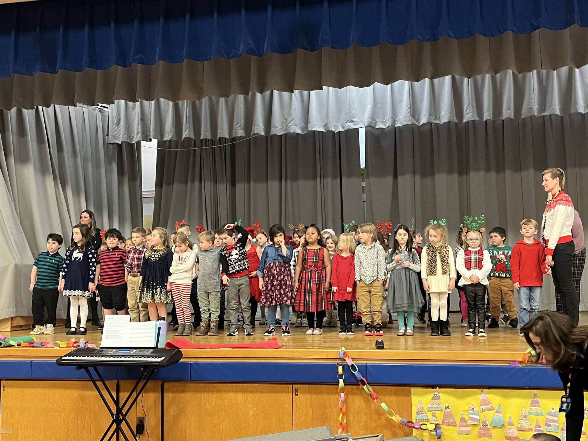 a large group of students on stage with gray curtain background