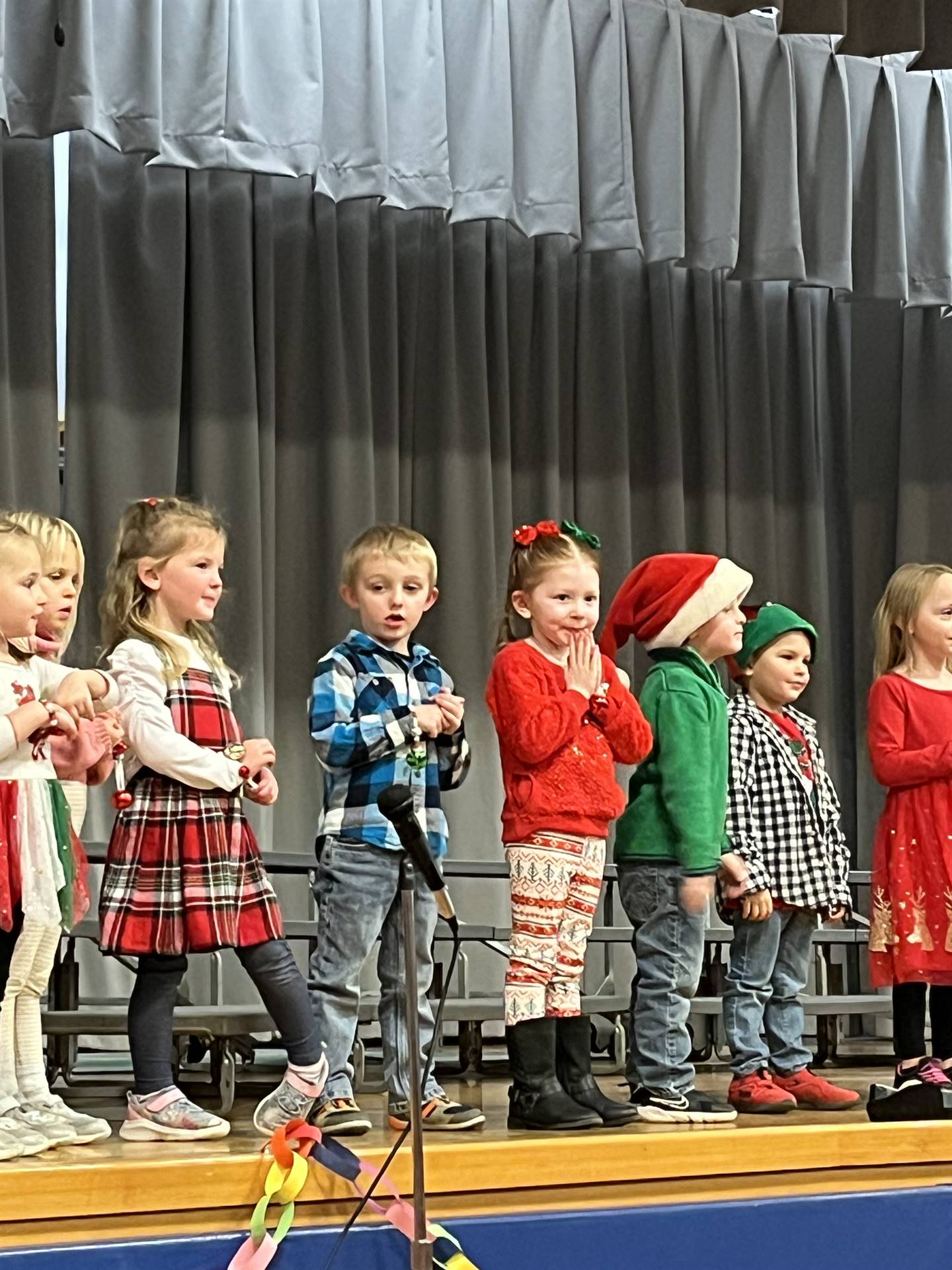 a large group of students on stage with gray curtain background