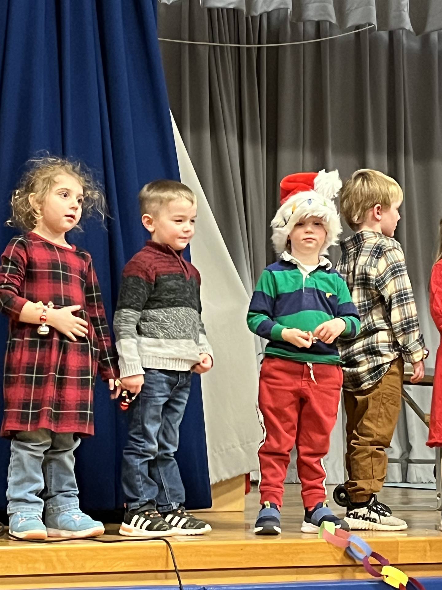 a large group of students on stage with gray curtain background