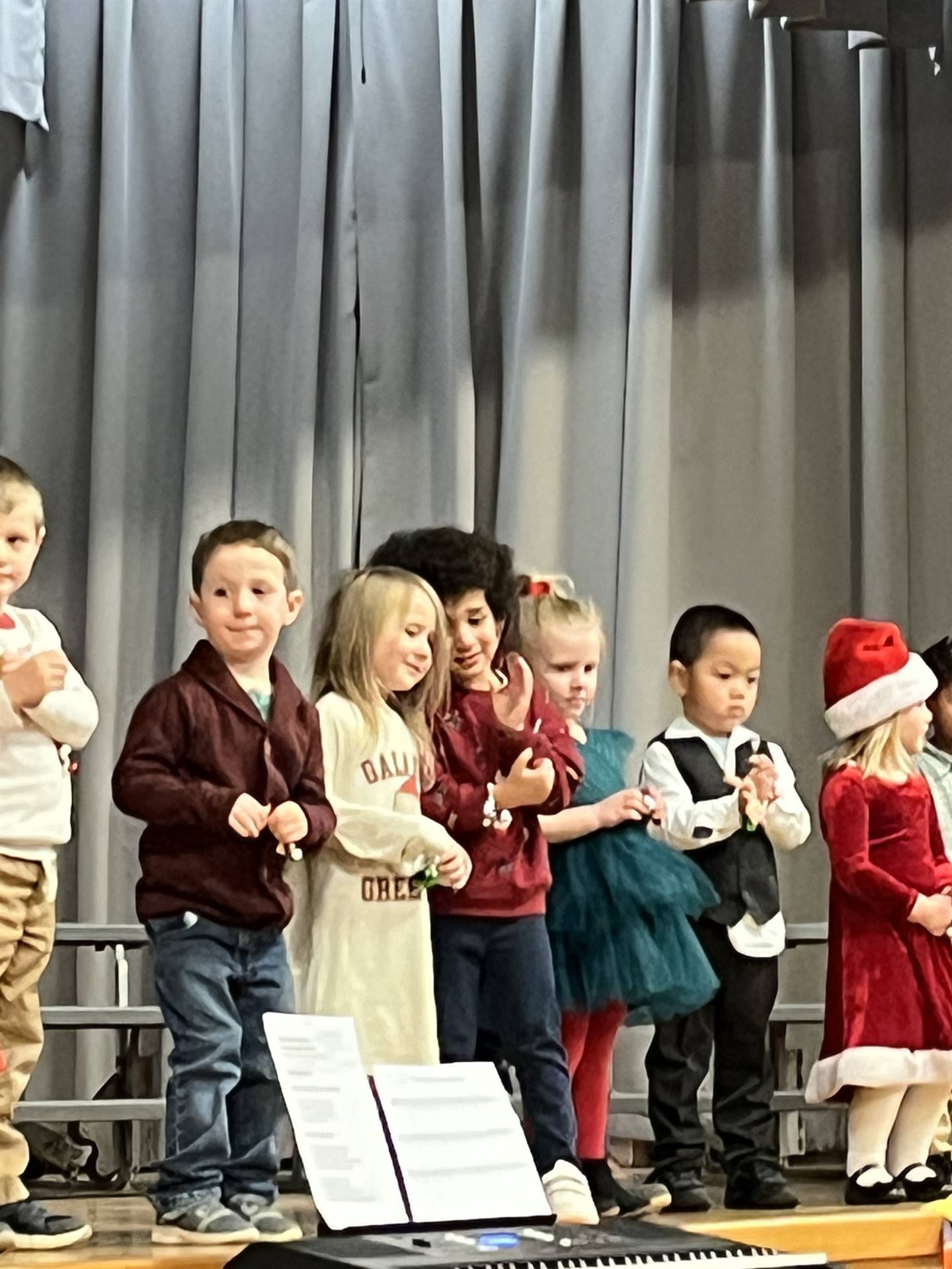 a large group of students on stage with gray curtain background