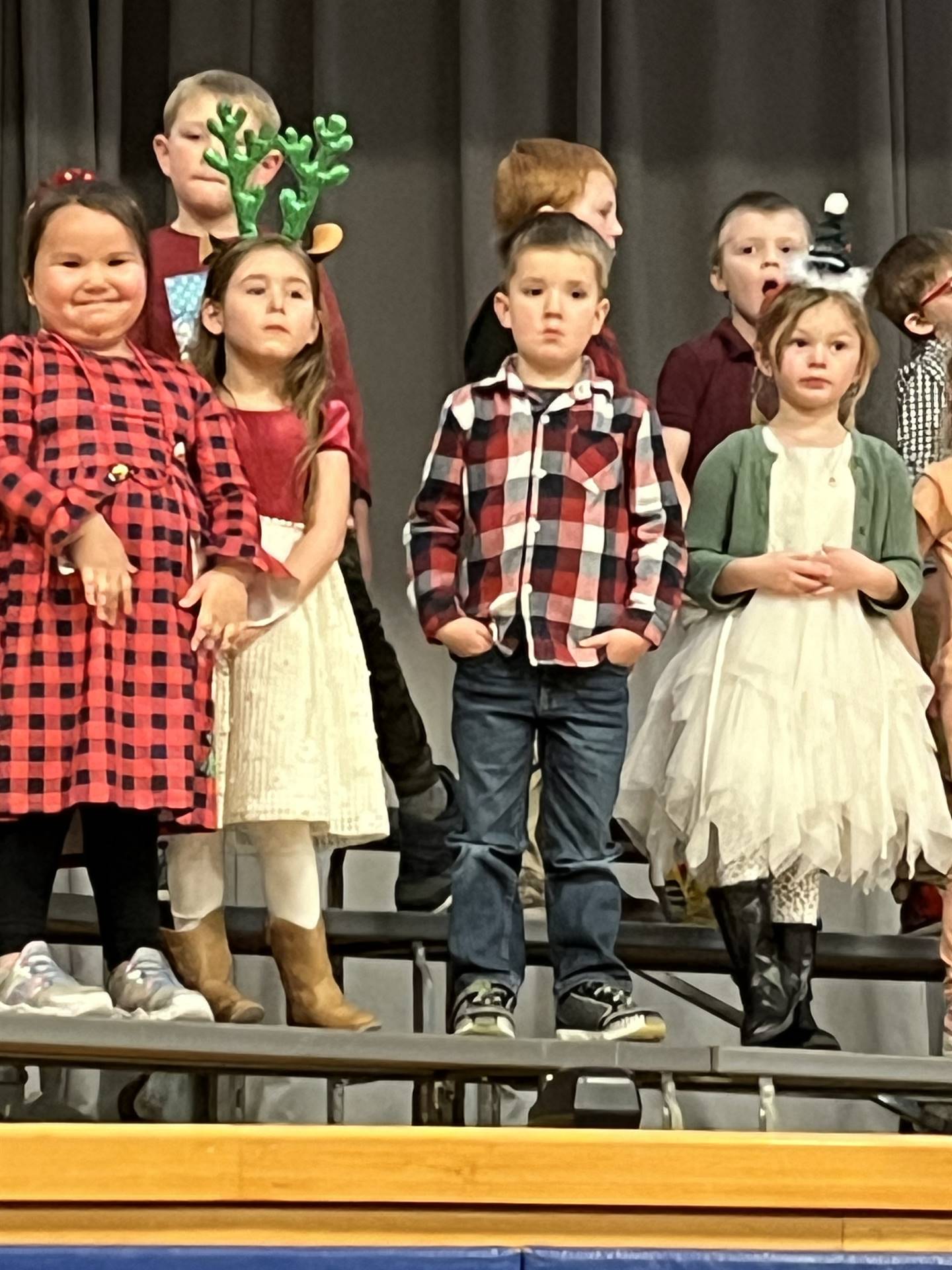 a large group of students on stage with gray curtain background