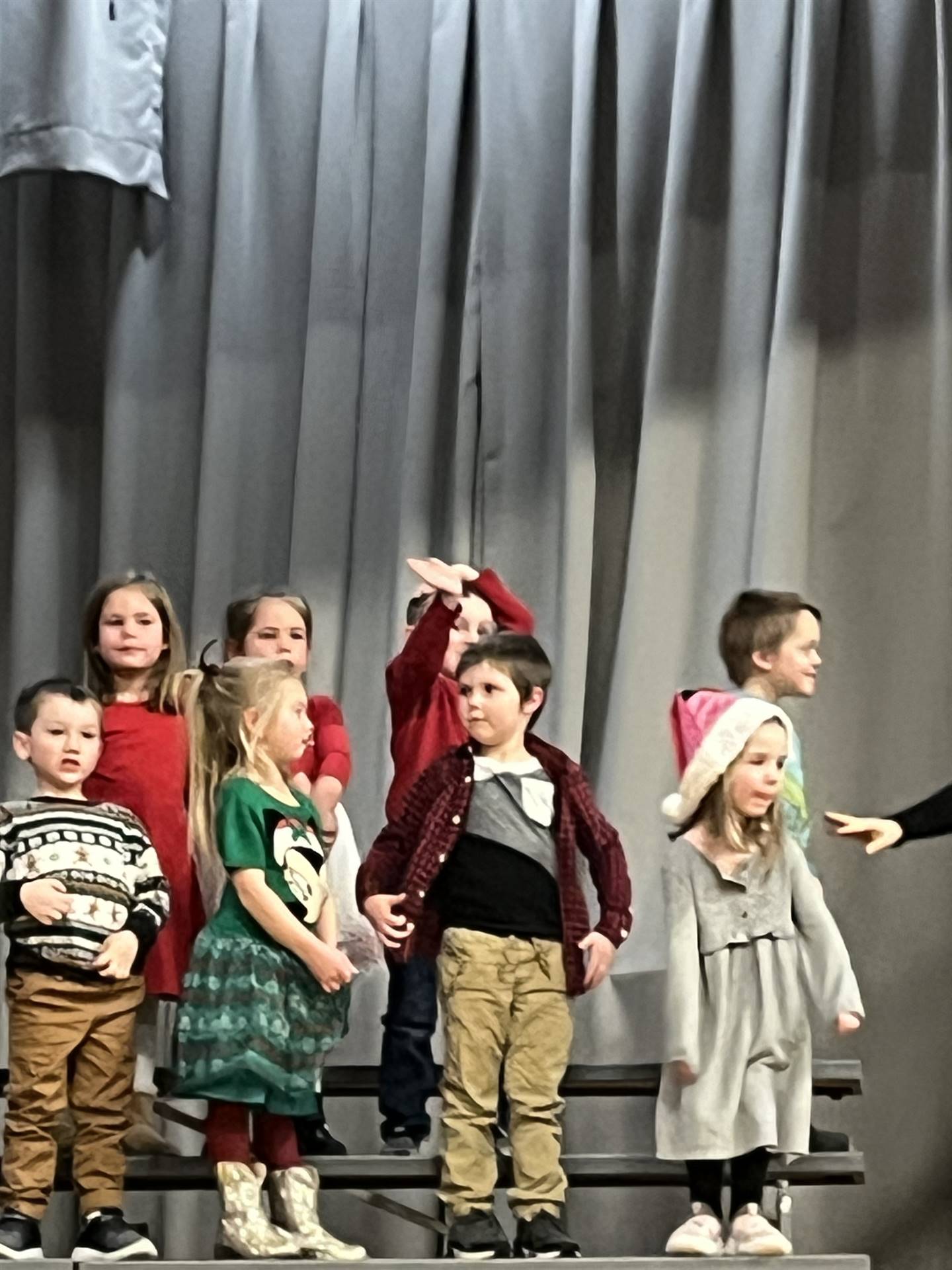 a large group of students on stage with gray curtain background