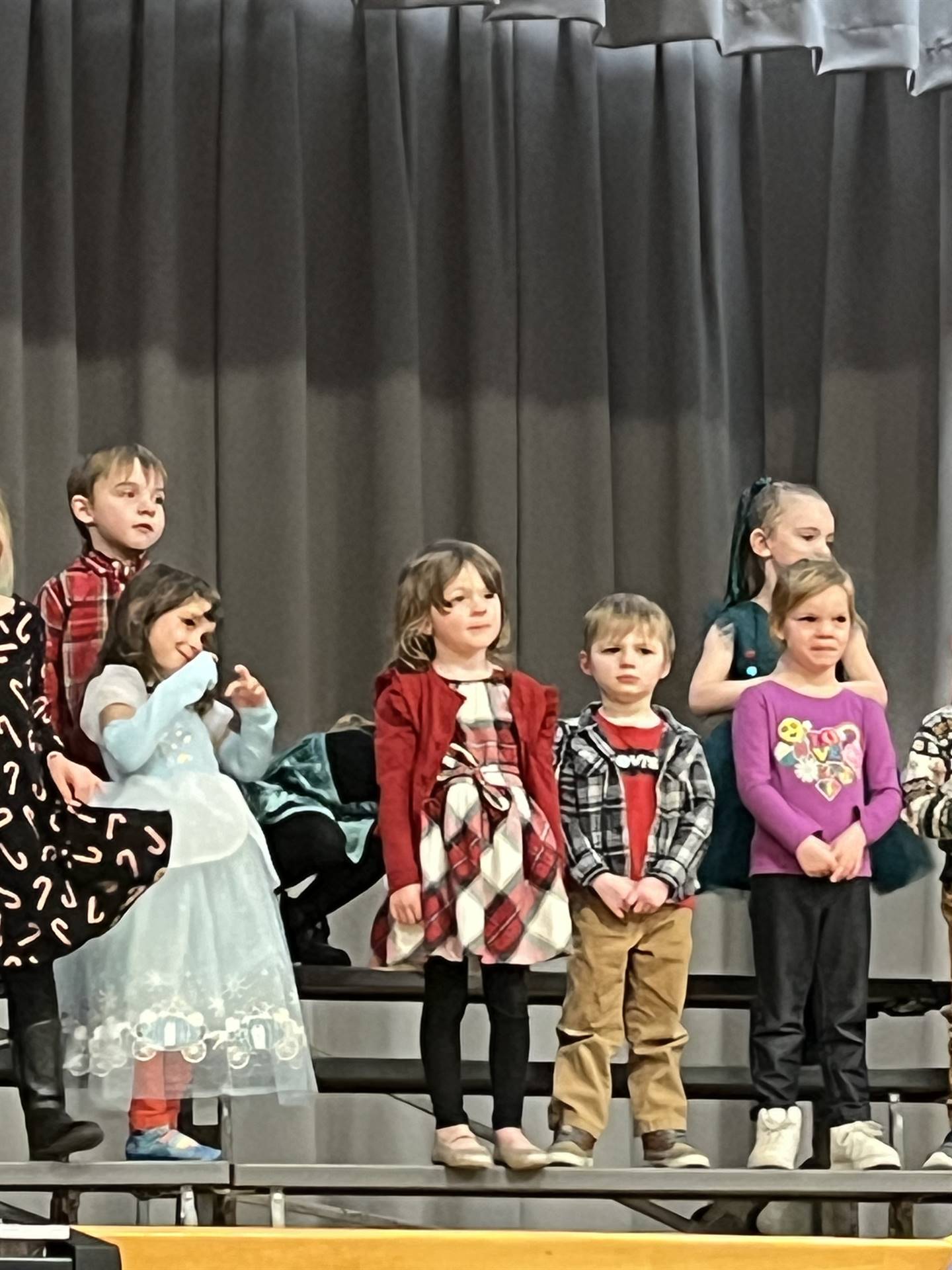 a large group of students on stage with gray curtain background