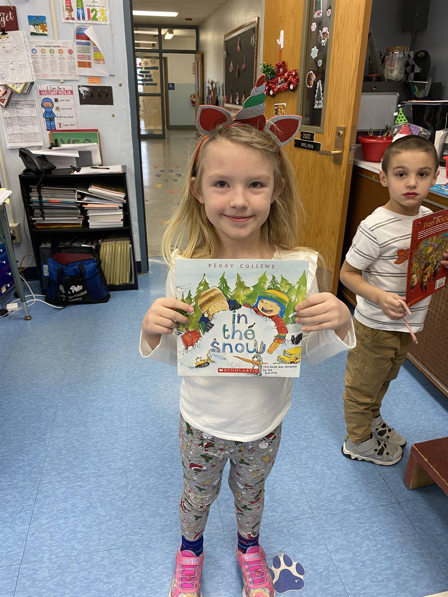 student holds up a book that was gifted by Santa Claus.