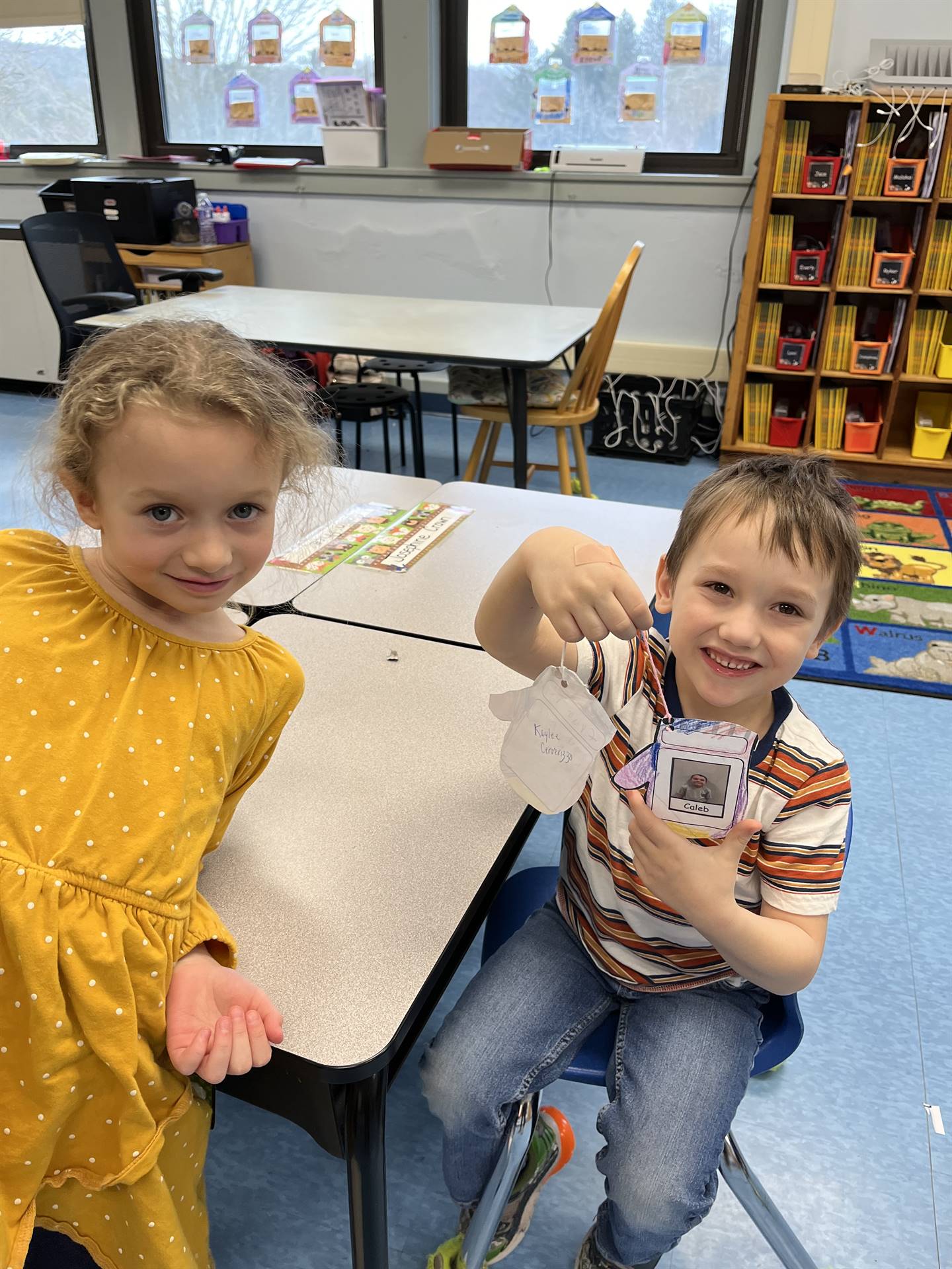 A student hands a paper mitten with a compliment written on it.