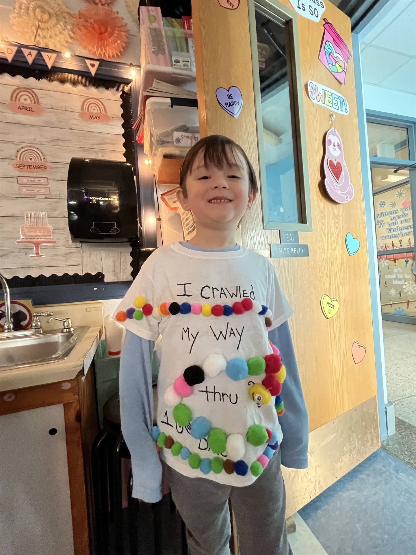 a student with pompoms on shirt that says I am 100 days smarter