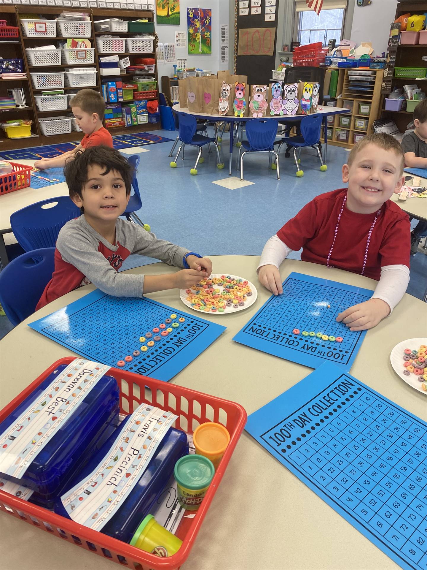 2 students counting fruit loops on a blue counting board