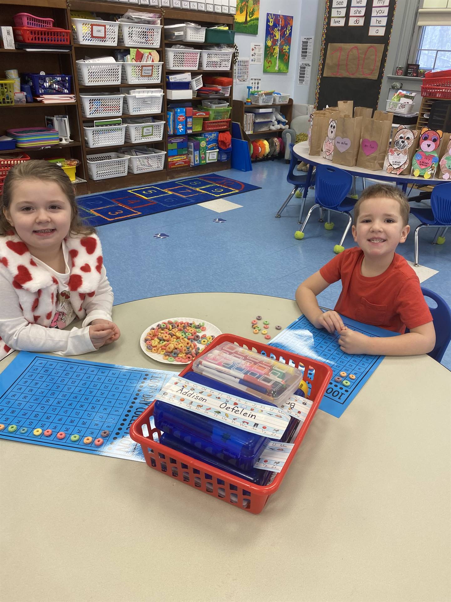 2 students counting fruit loops on a blue counting board