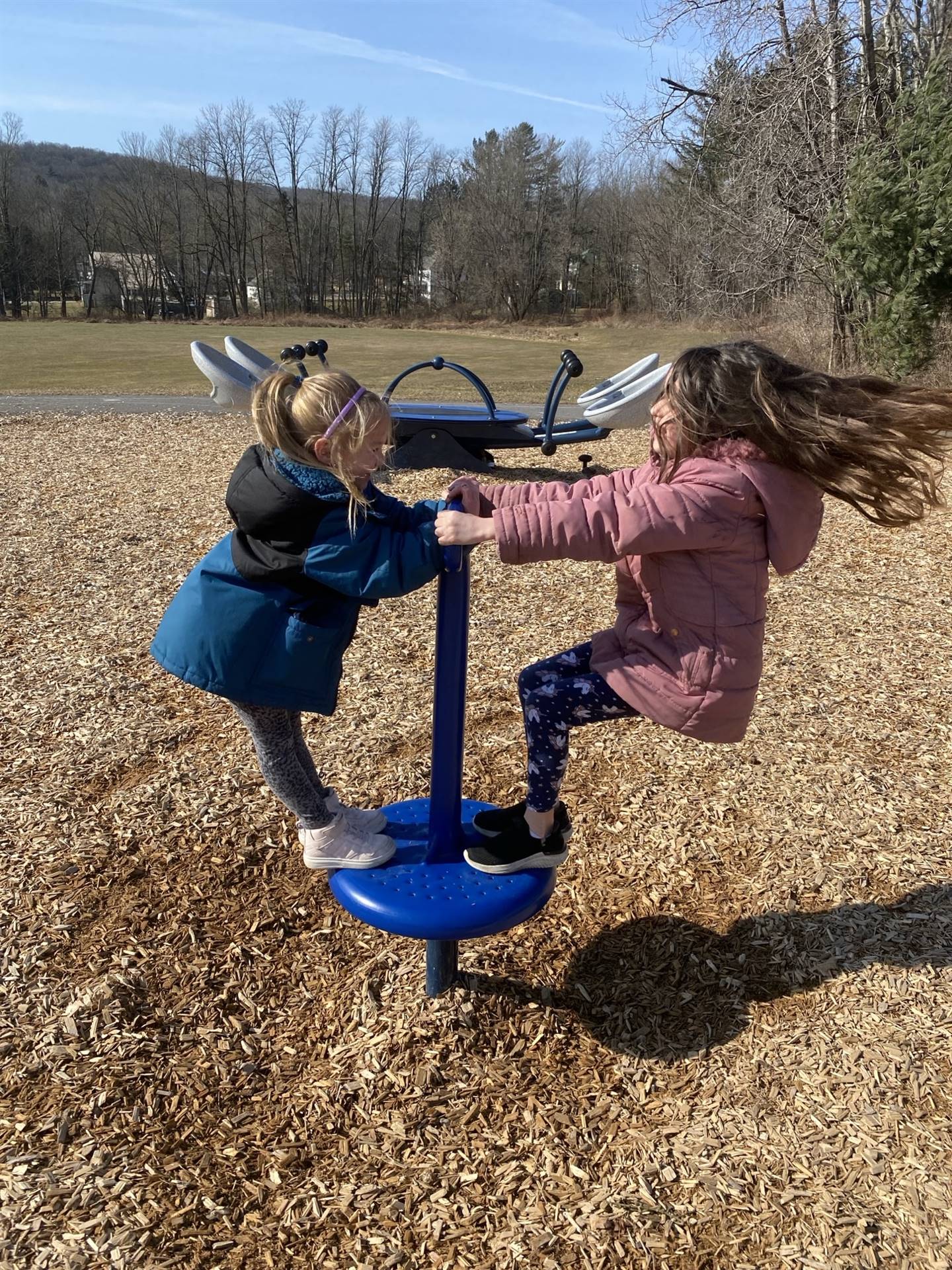 2 students on a twirler outside.