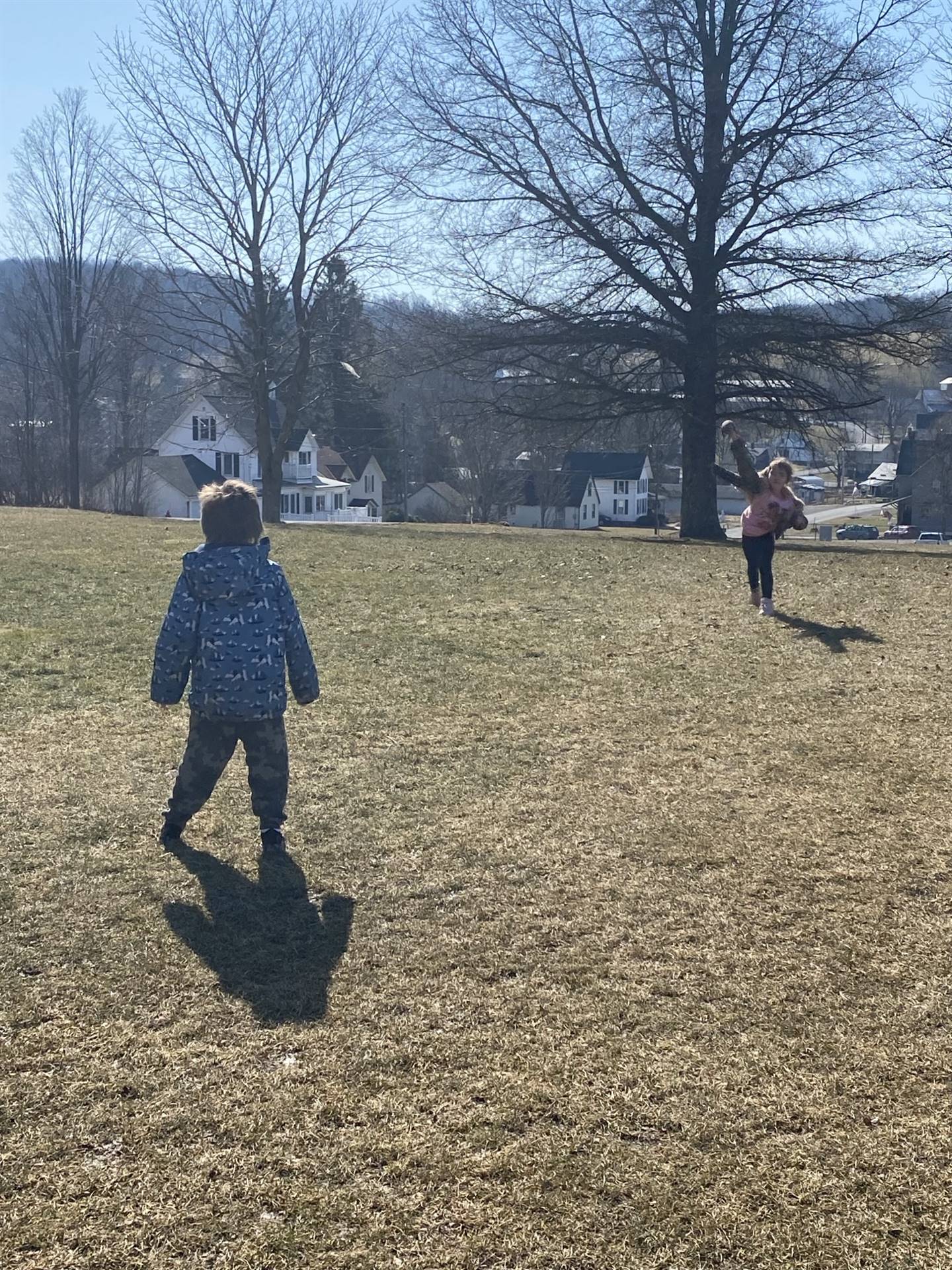 2 students playing toss with a ball outside