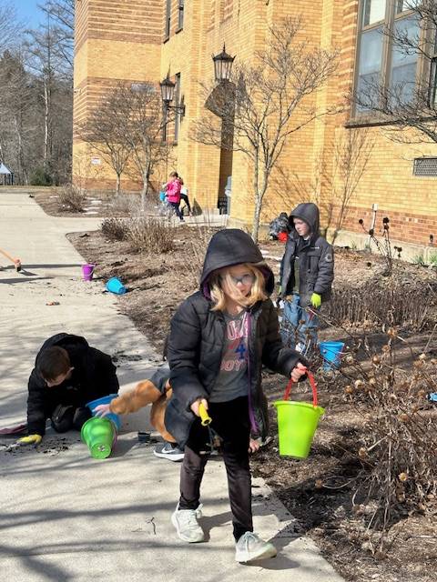 a student carries a yellow pail