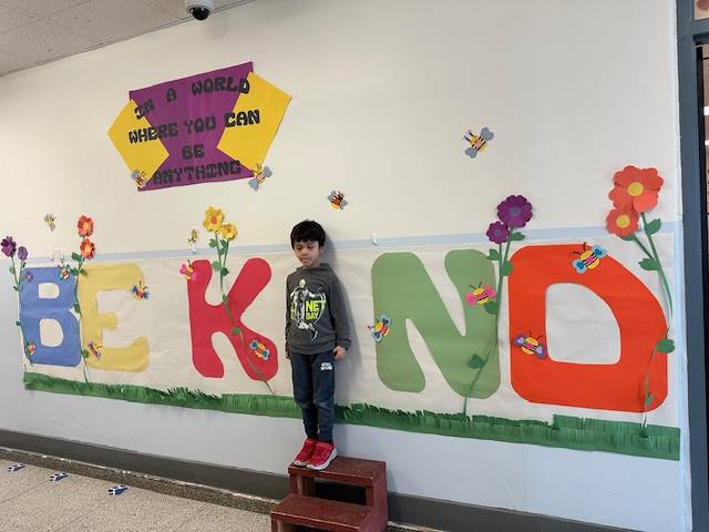 Student standing as "I" in word, "KIND"