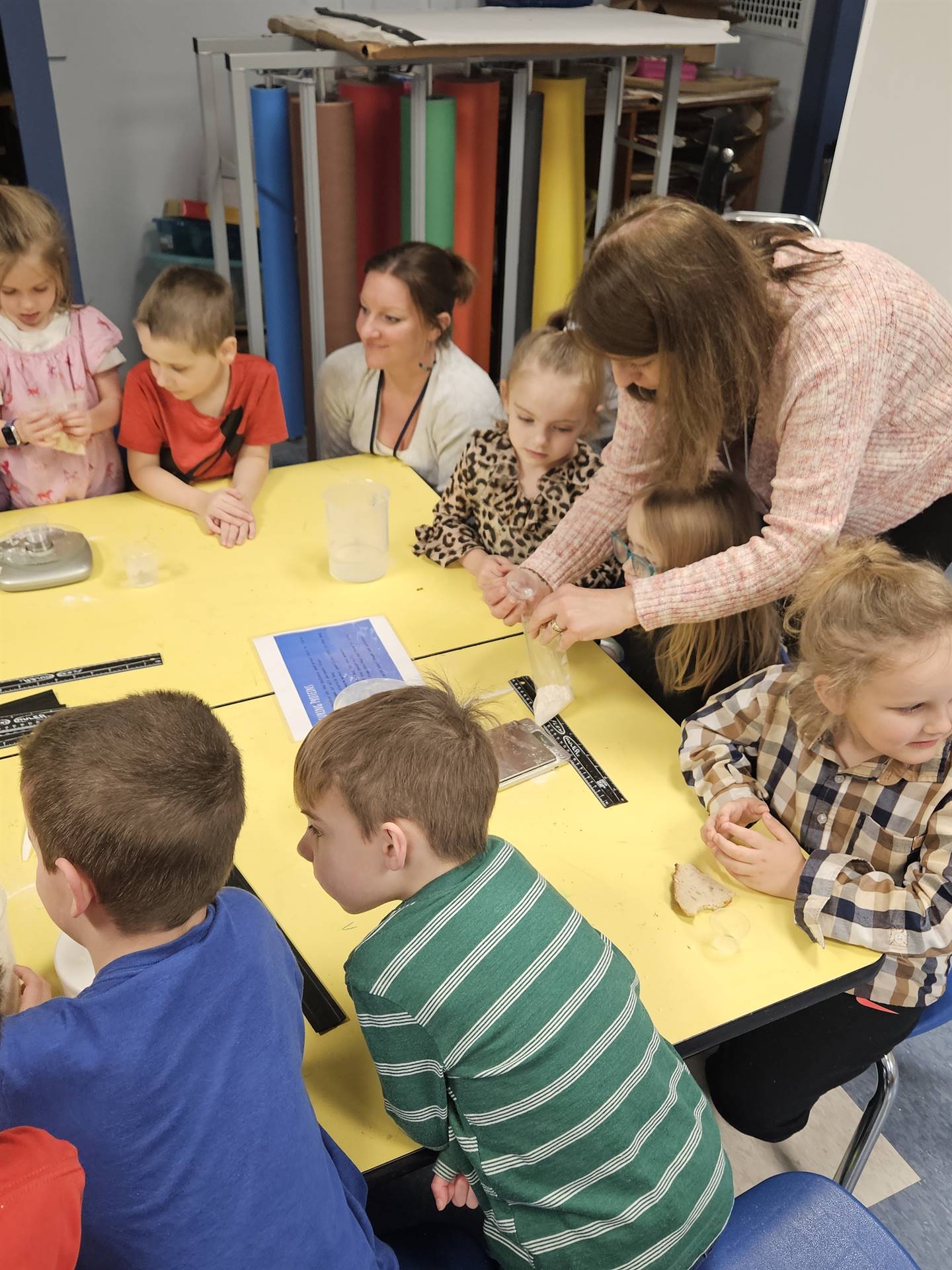 students are shown how to add flour to a bag.