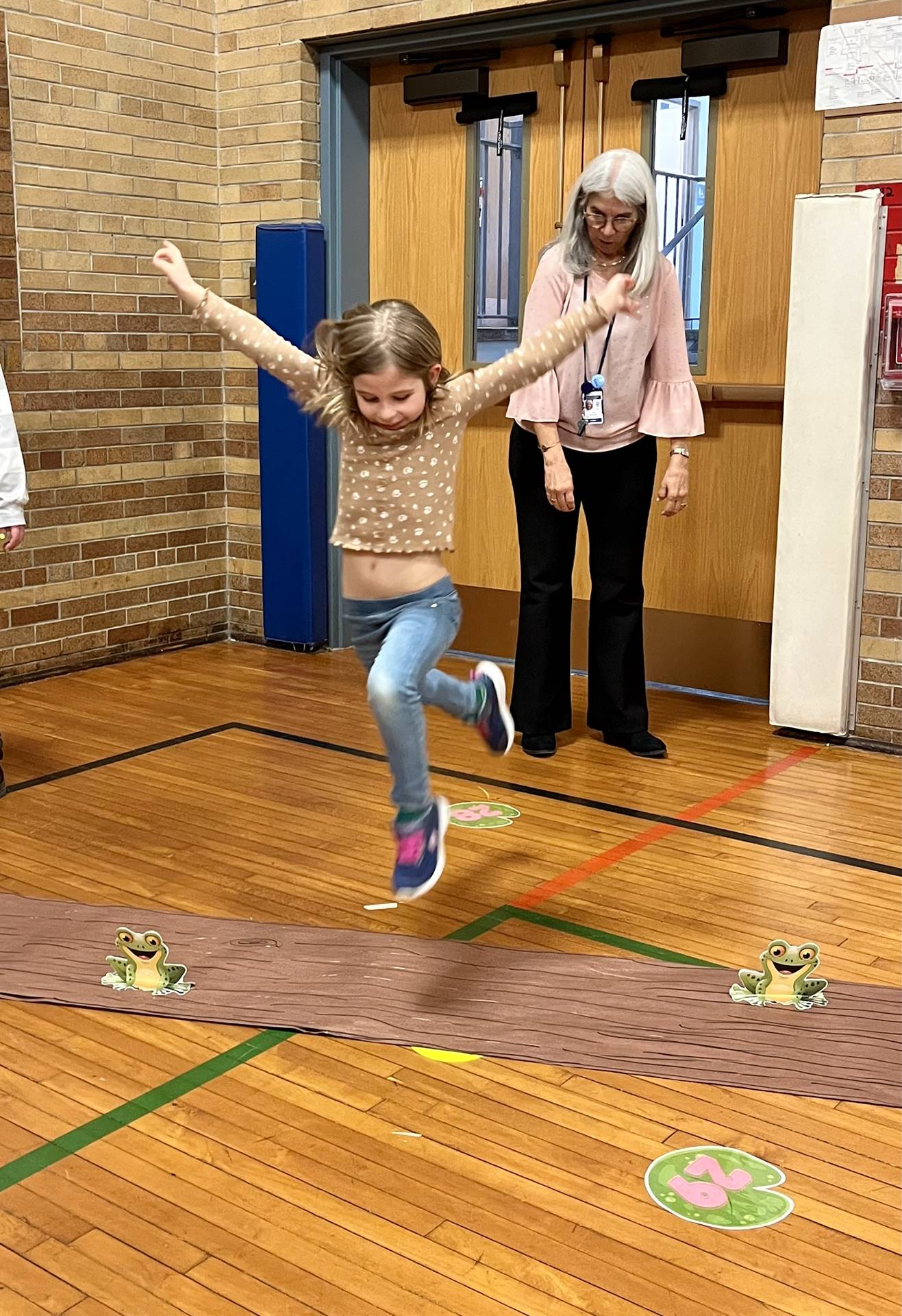 student  leaping over a paper log.