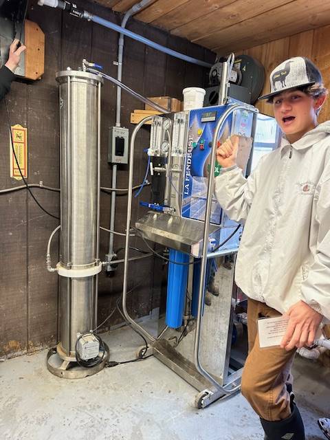high school student in front of maple syrup equipment