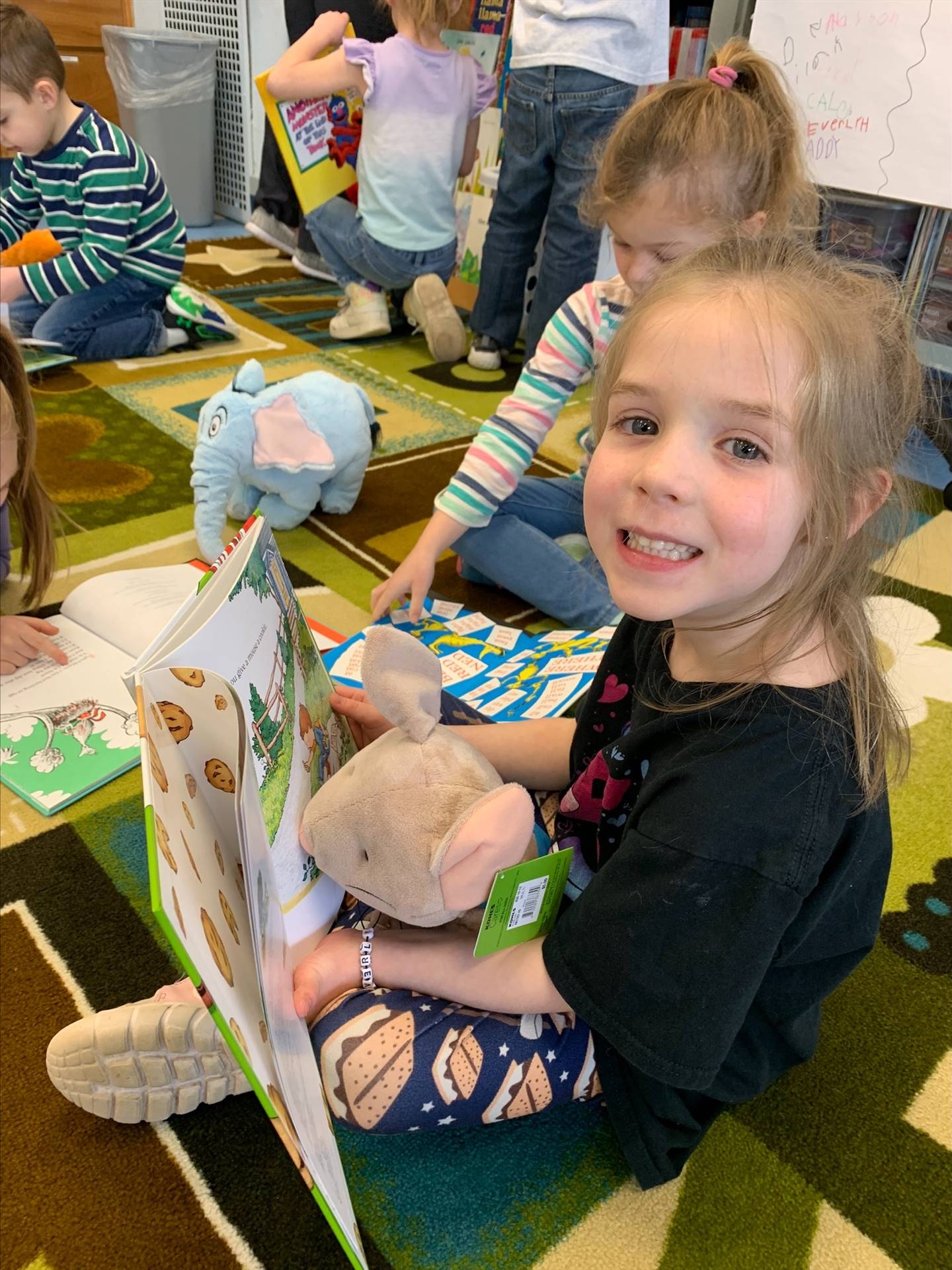 student reading to her stuffy.