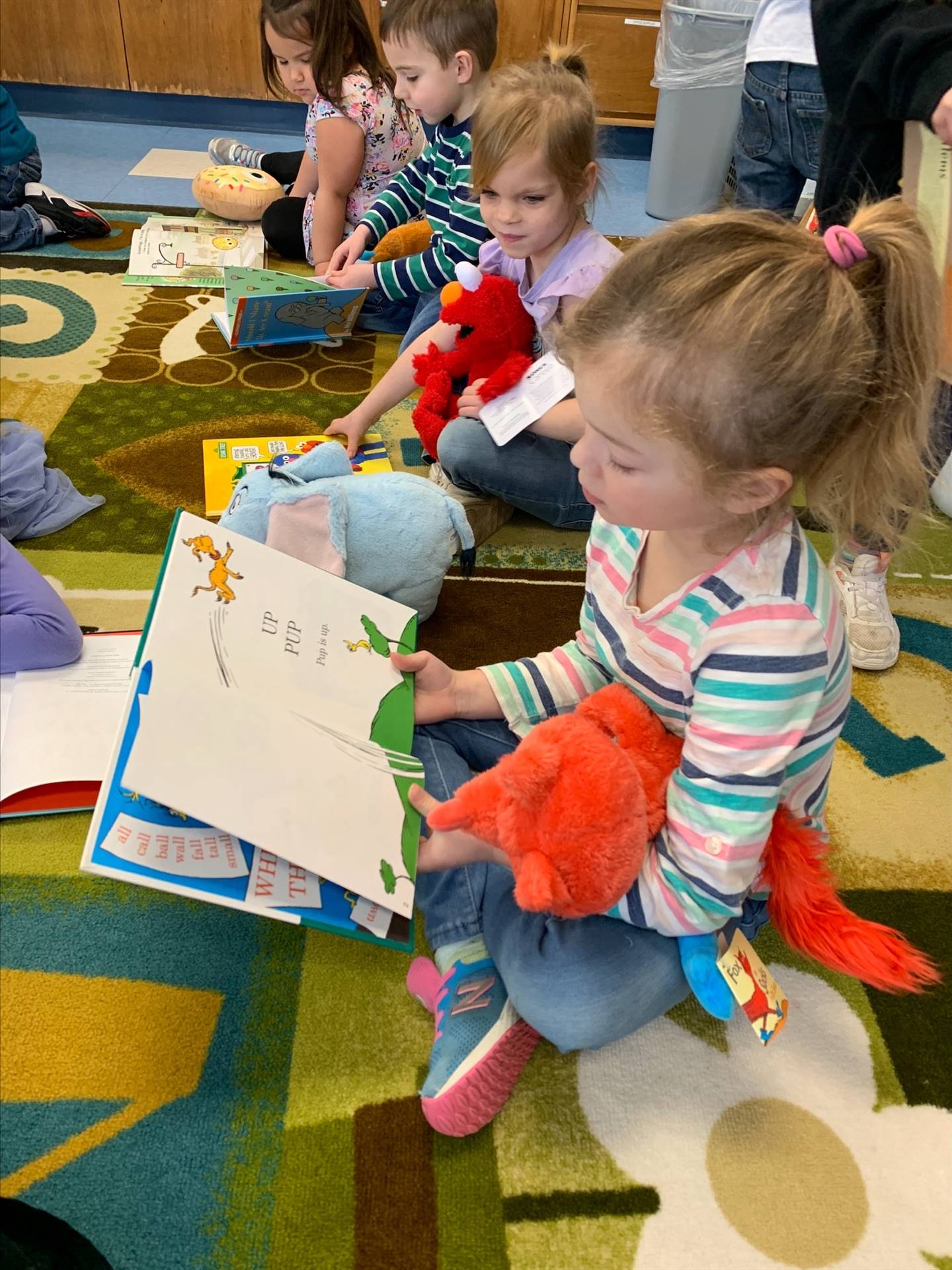 student reading to her stuffy.