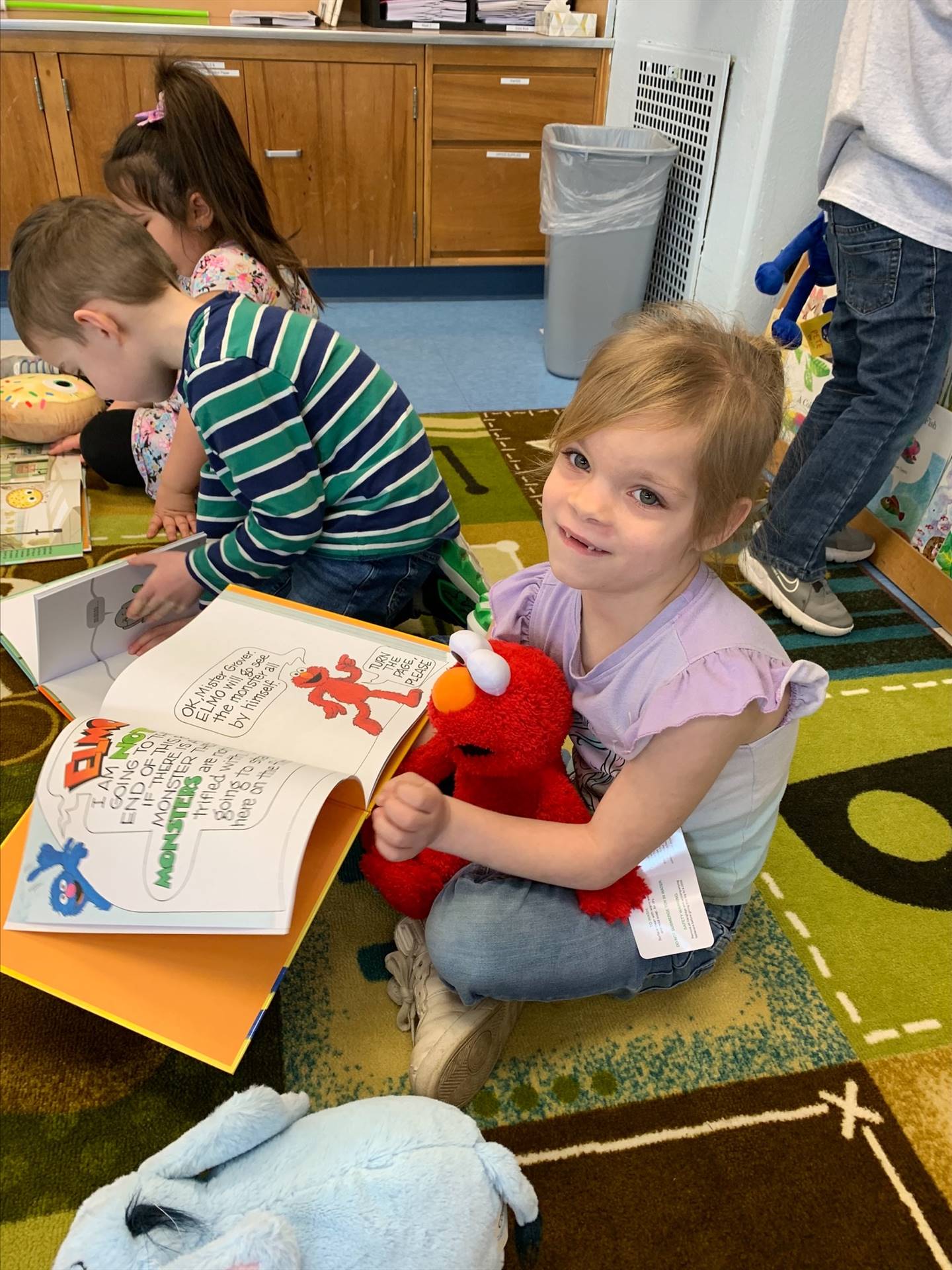 student reading to her stuffy.