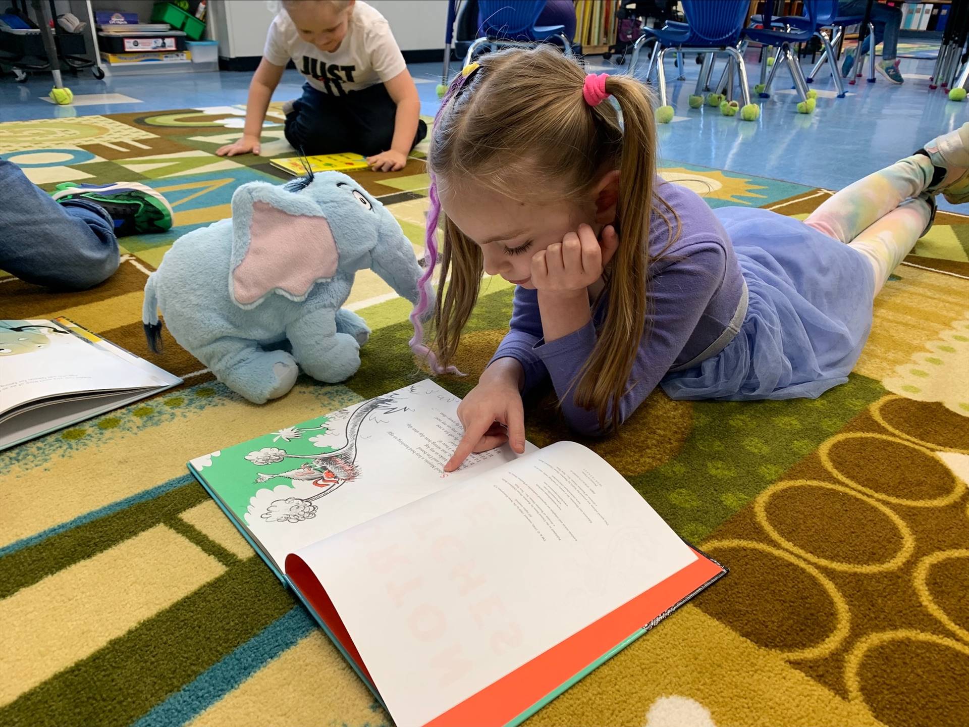 student reading to her stuffy.