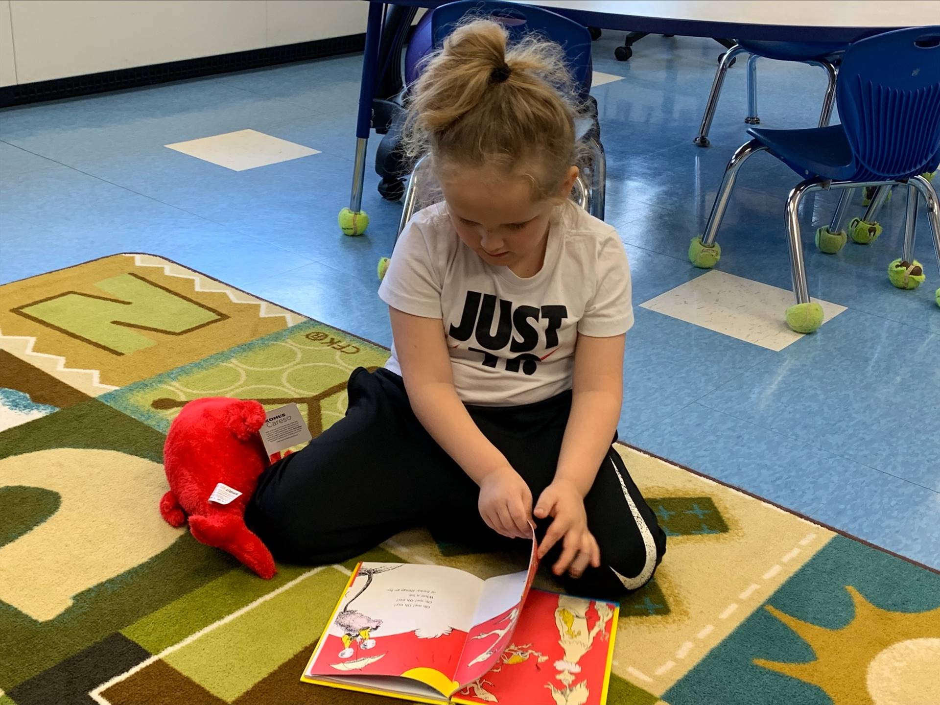 student reading to her stuffy.