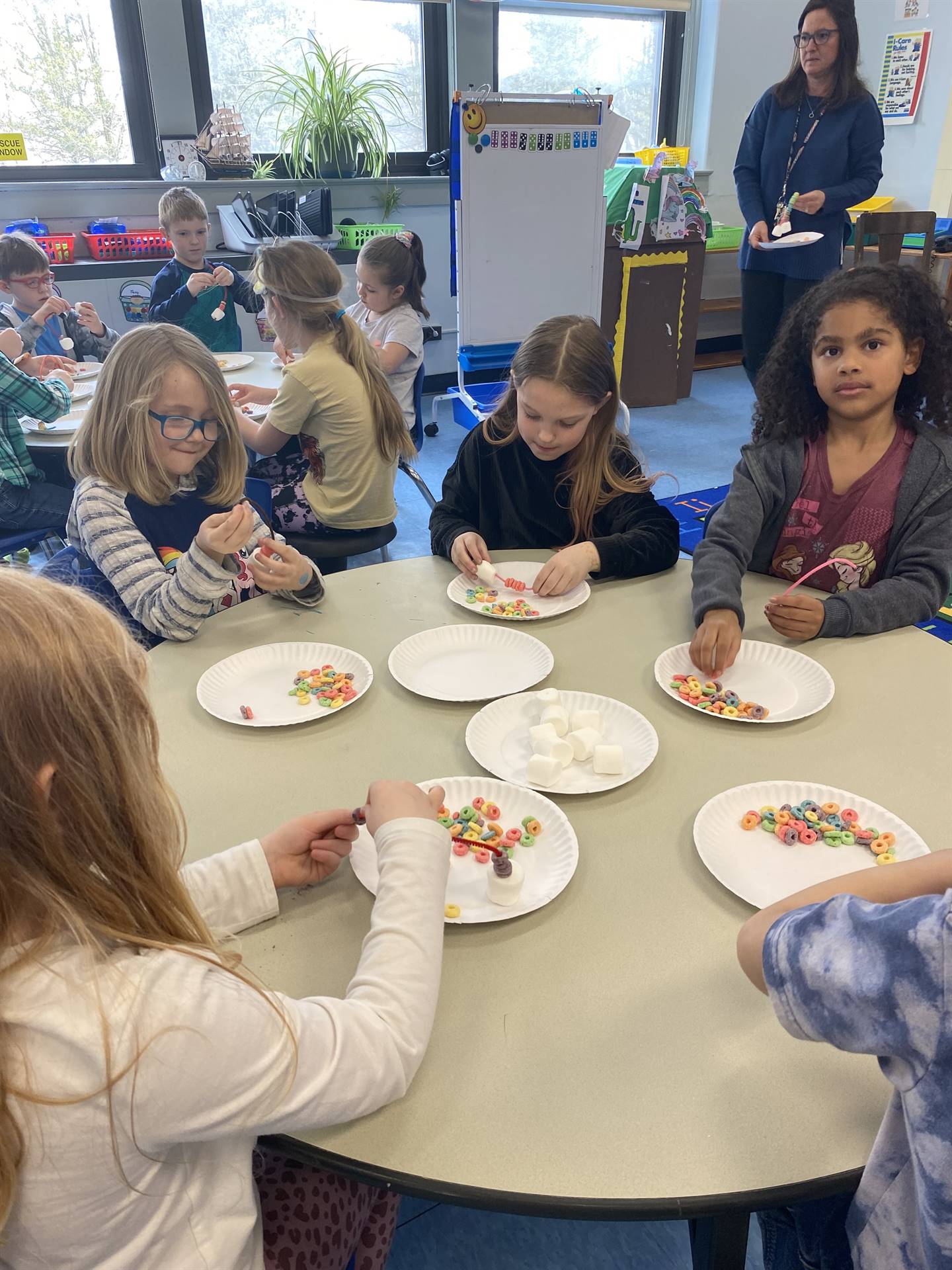 students use fruit loops to create a rainbow.