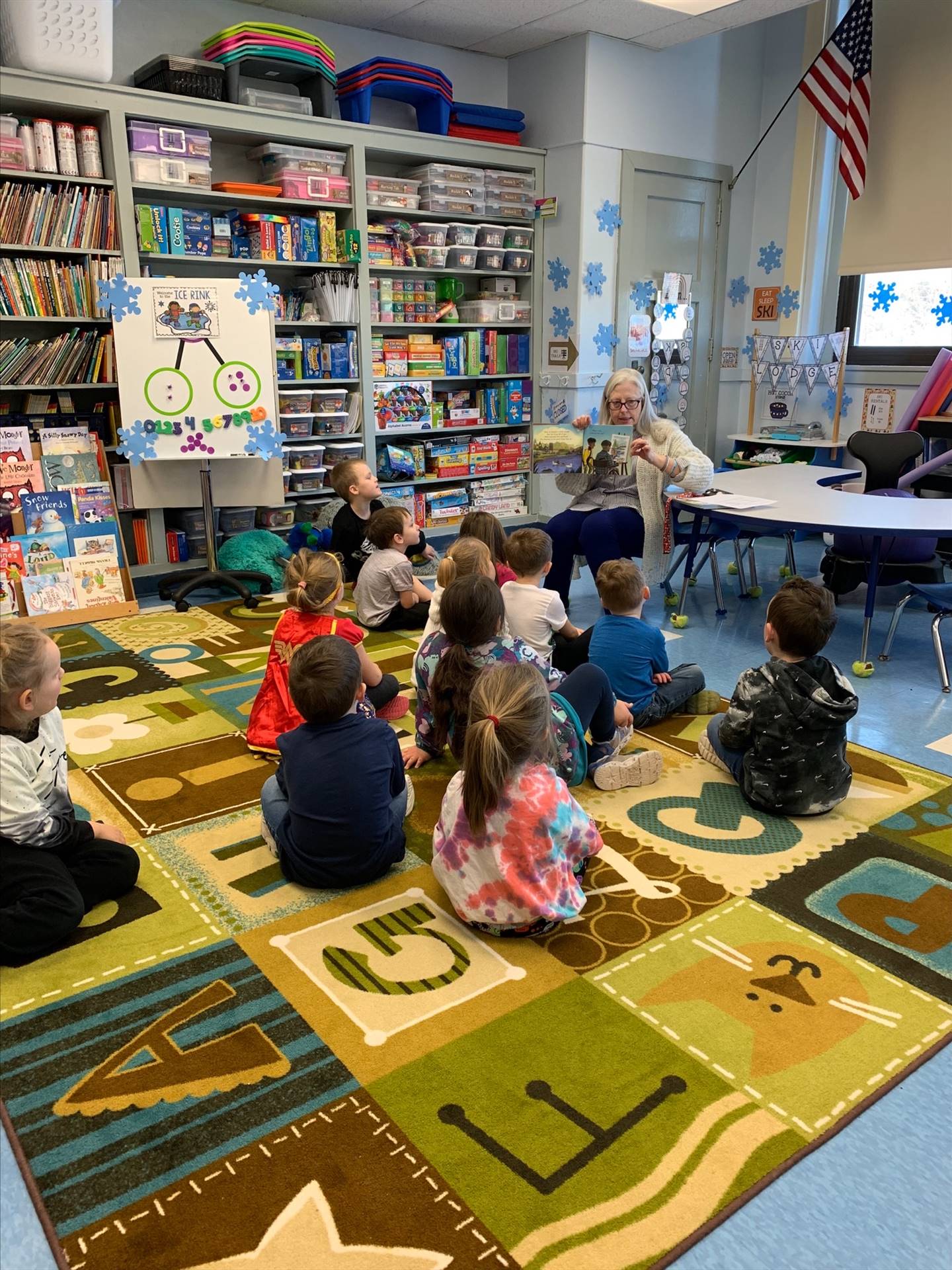 students listen to an adult read a book.