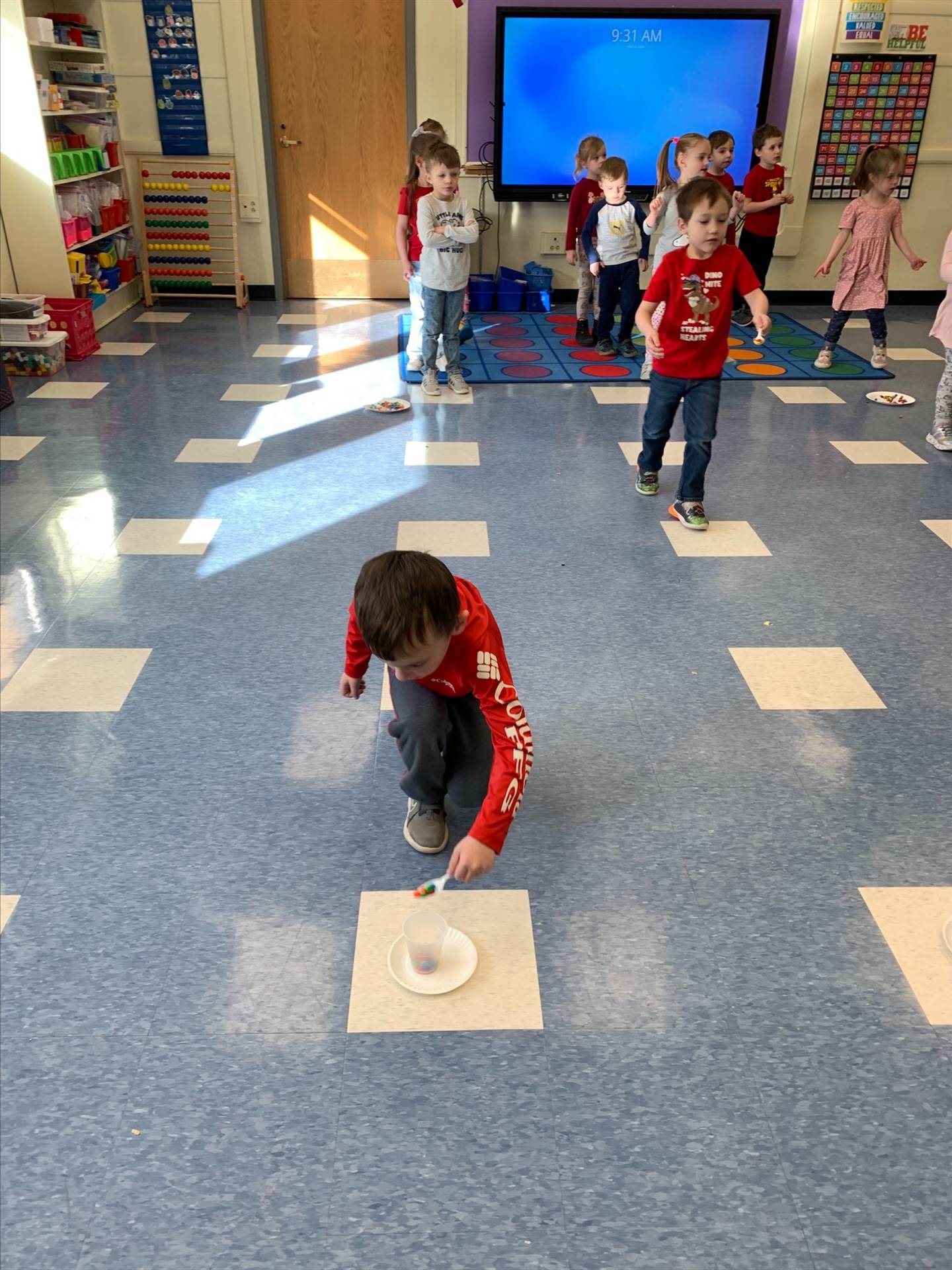 student is doing a craft on floor.