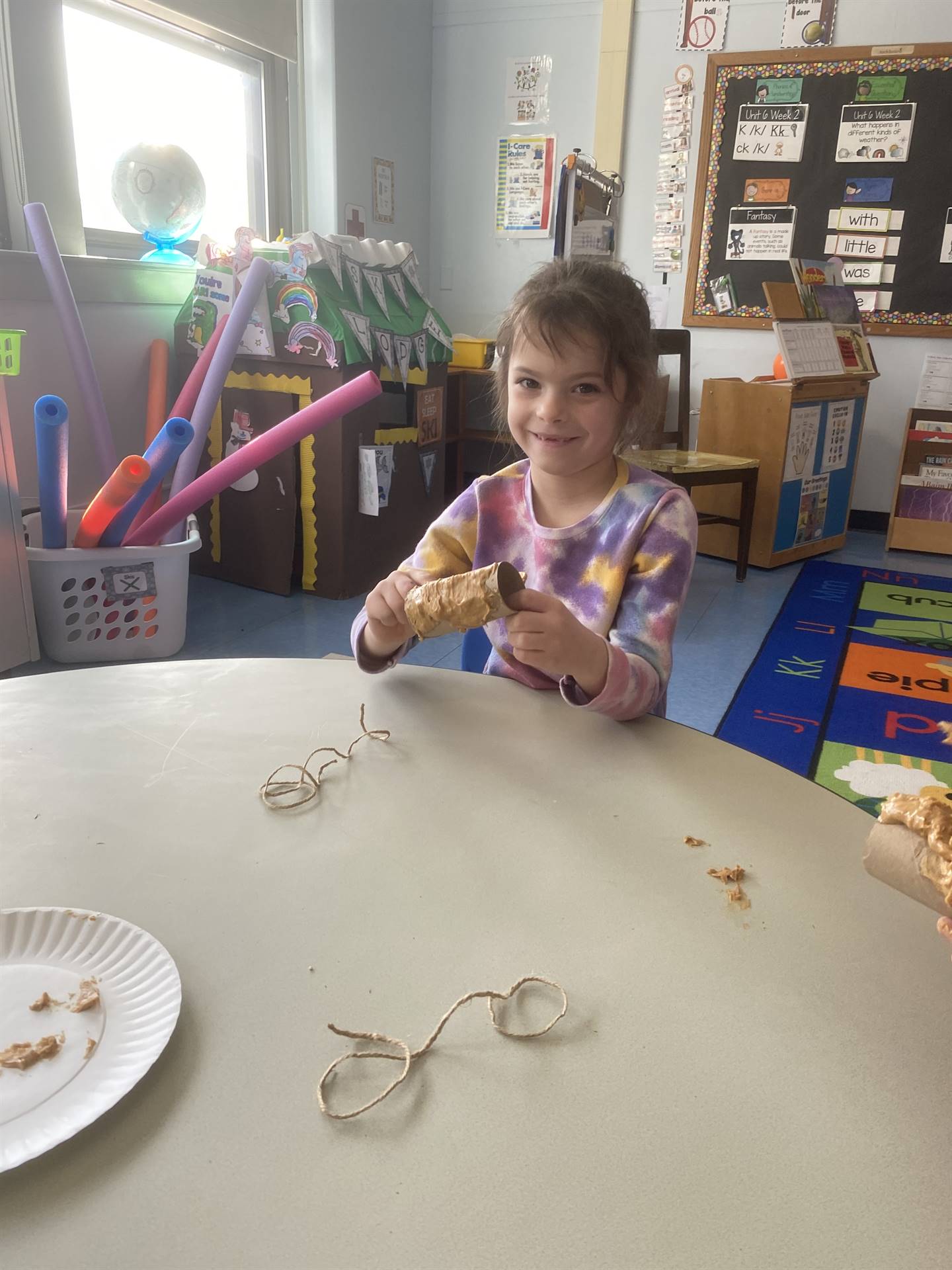 a student shows a peanut butter covered tube