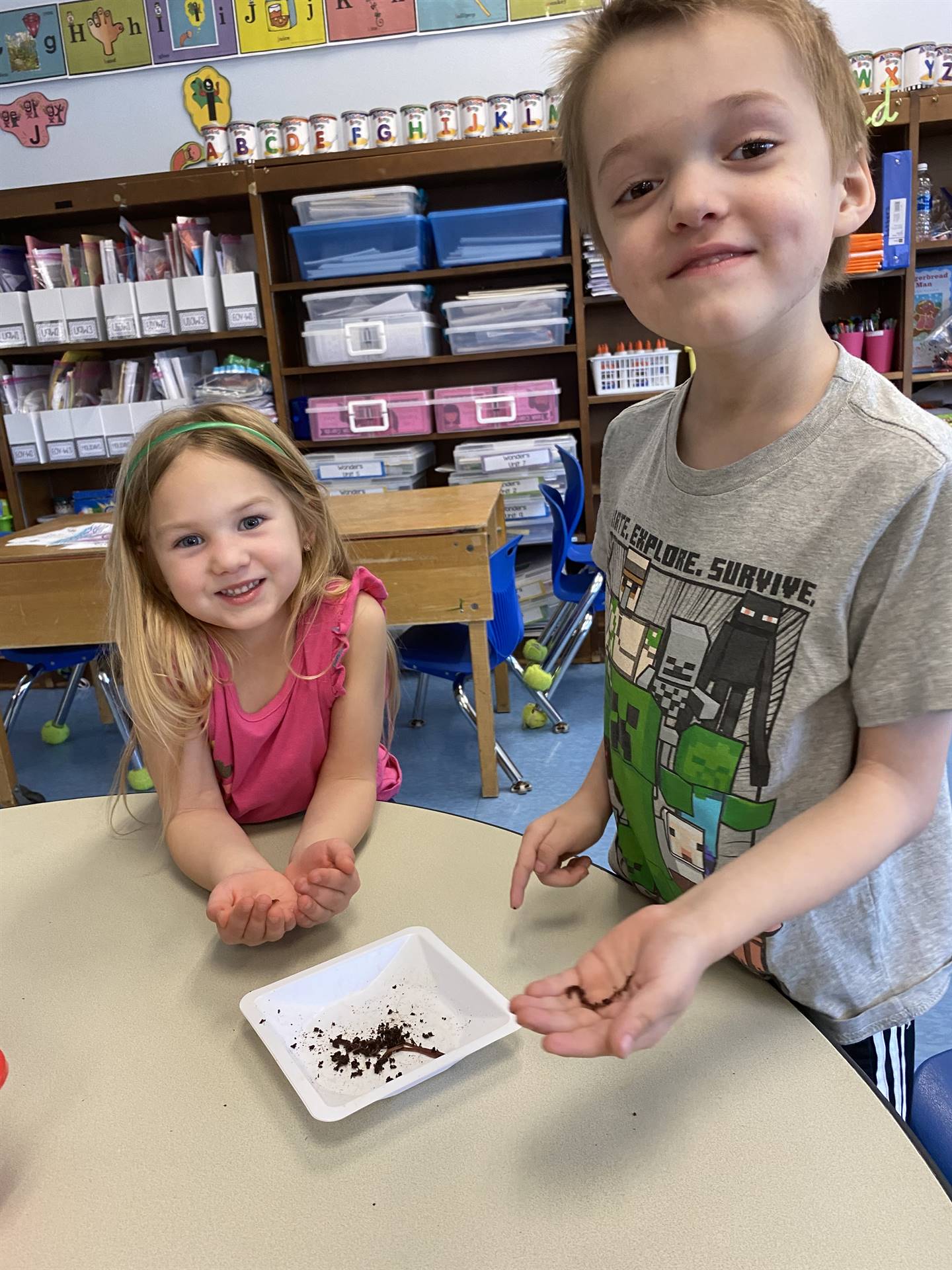 2 students with worms on a white plate