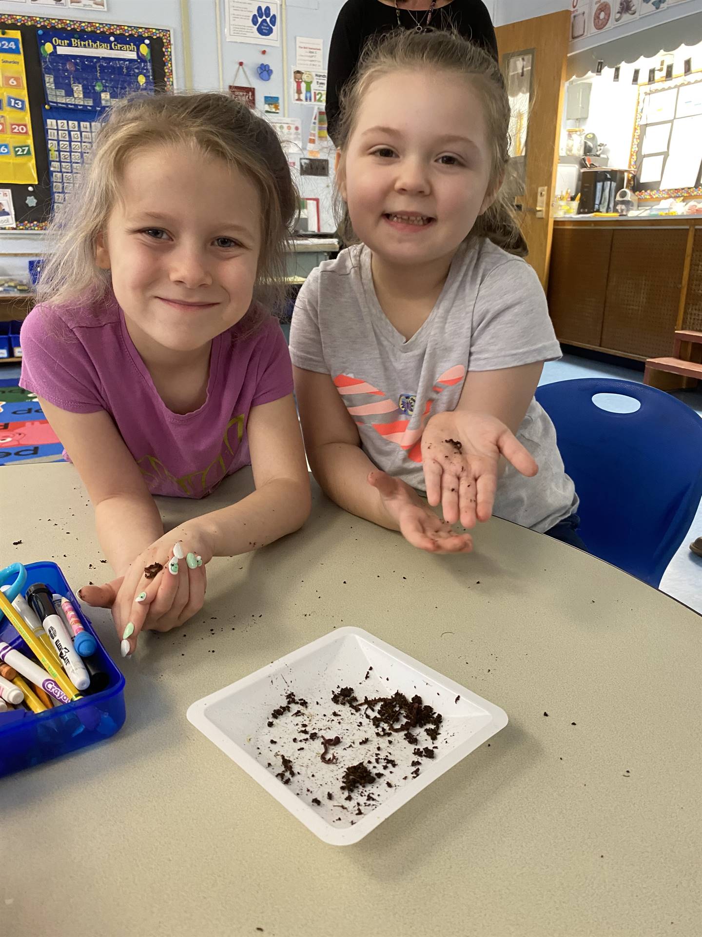 2 students with worms on a white plate