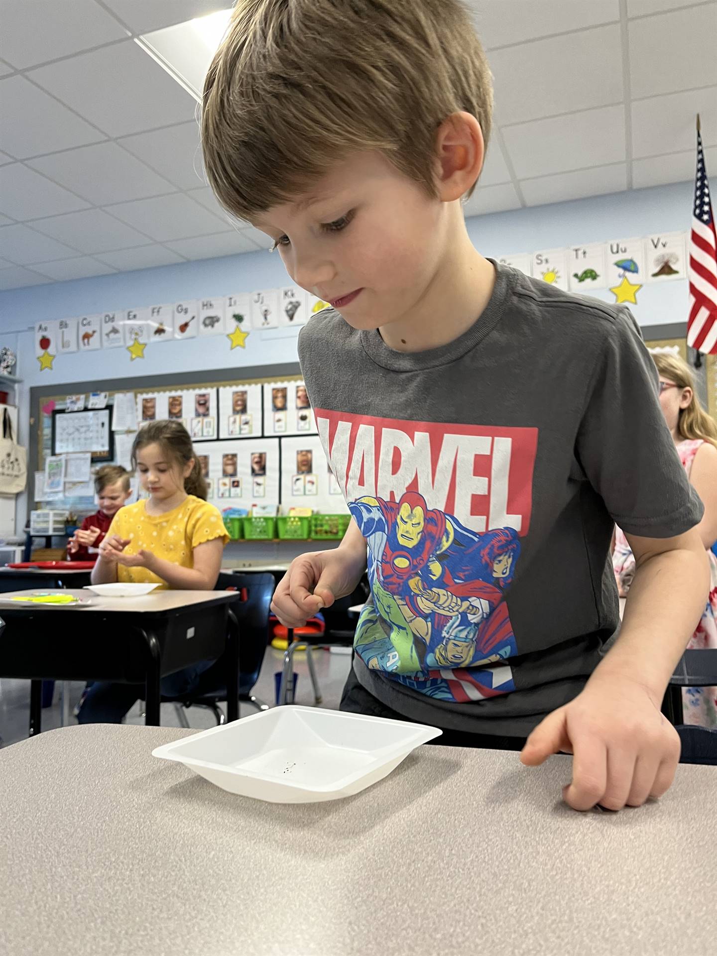 a student observes a worm on a white plate