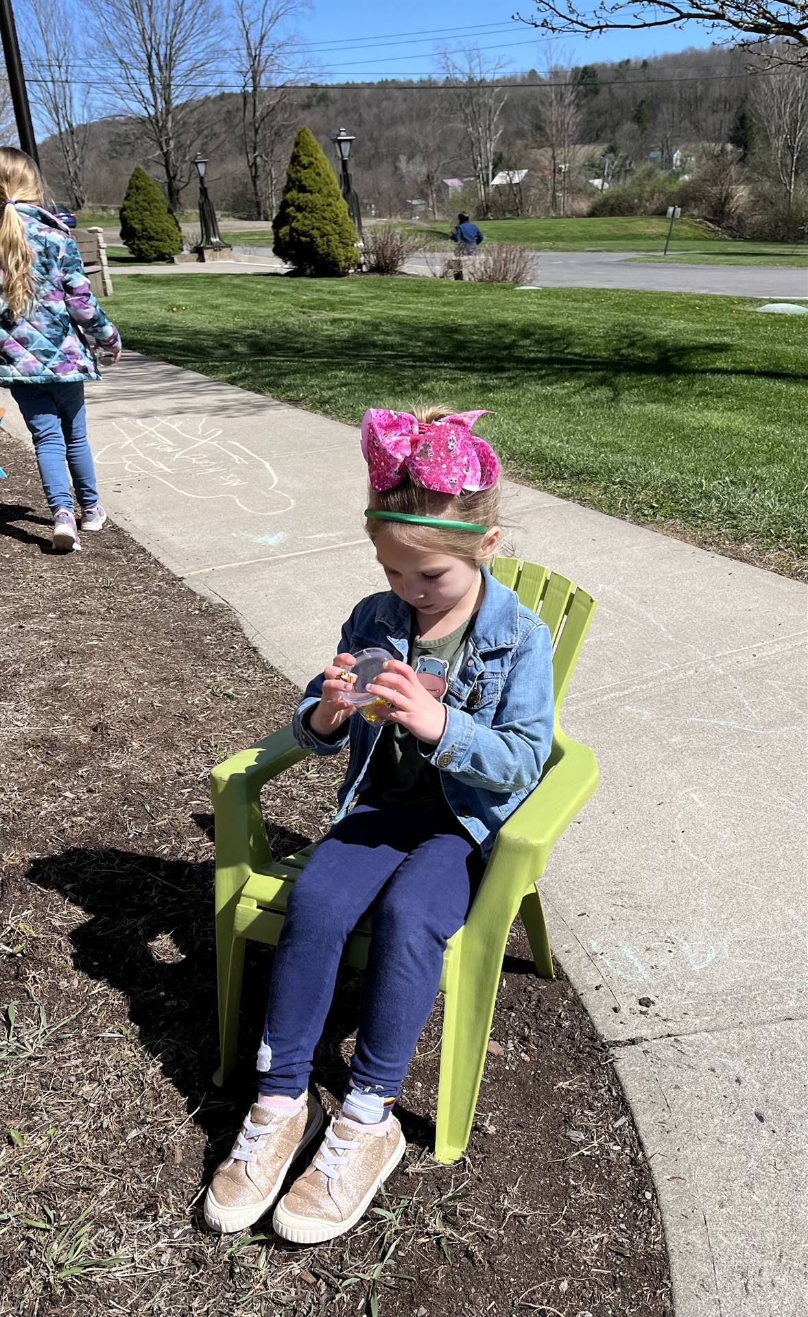 1 student in chair looking in a magnifying jar.