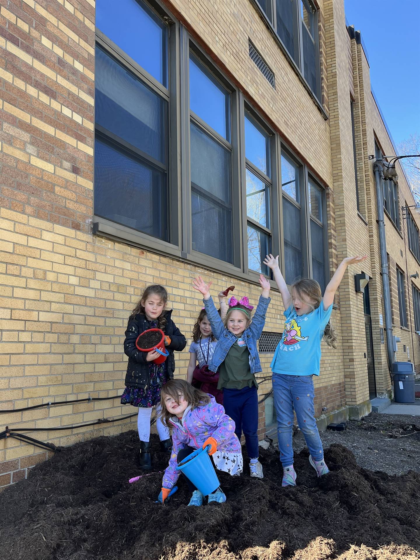 students on top of a pile of mulch