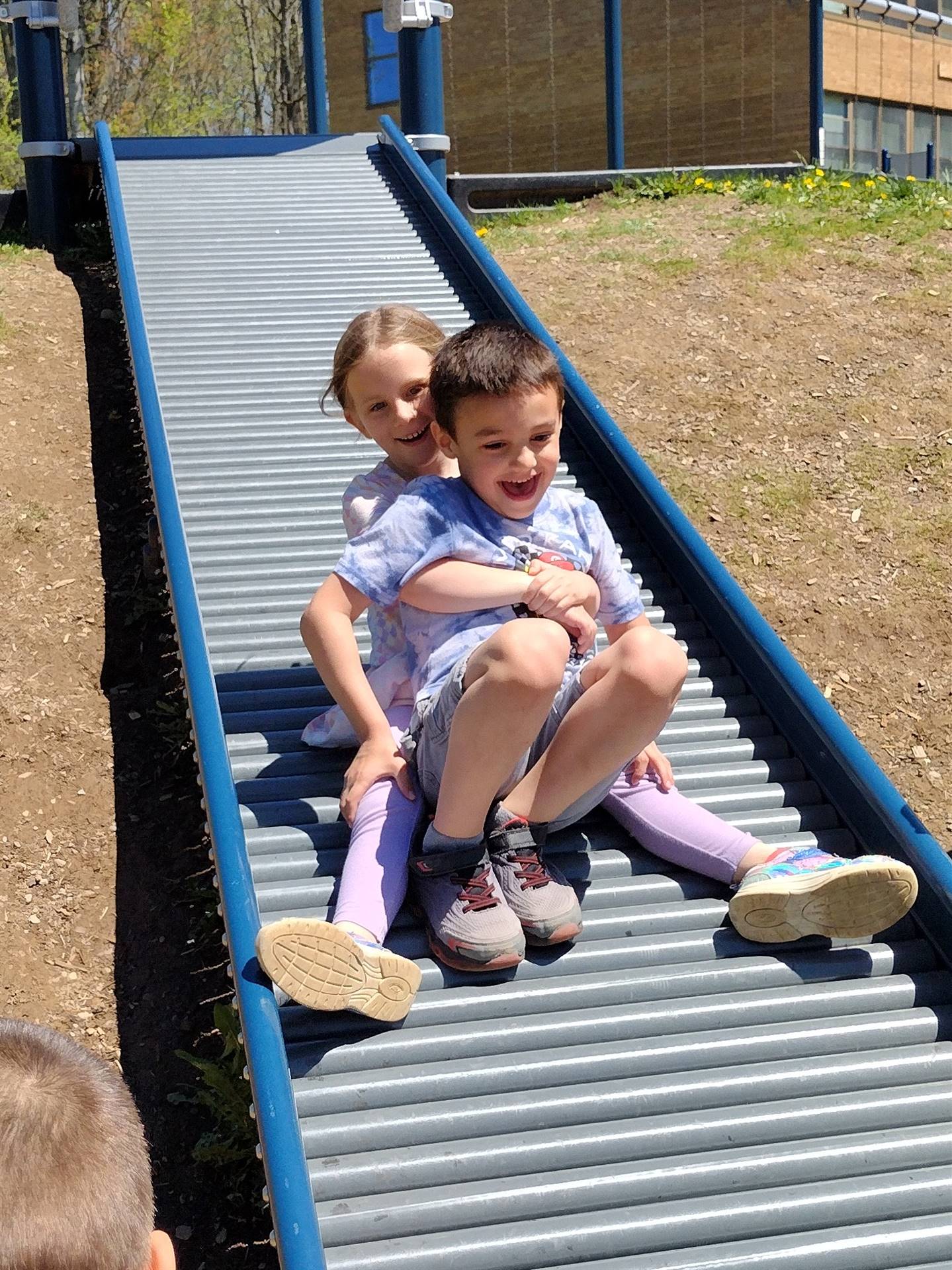 2 students  going down a slide