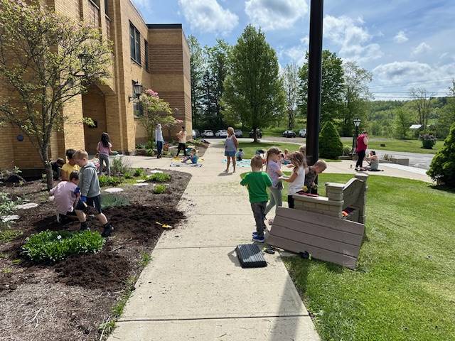 students outside in pollinator garden.