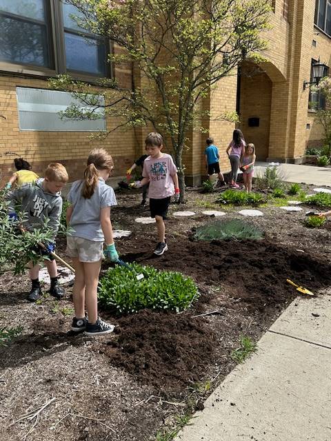 students walking through a pollinator garden