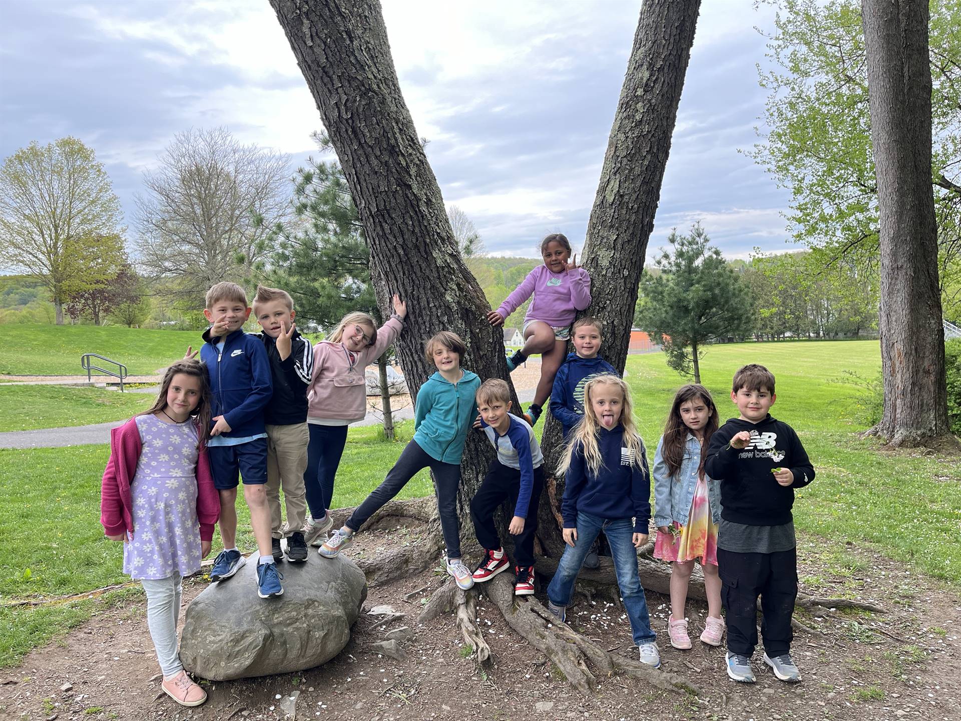 students outdoors with tree background.
