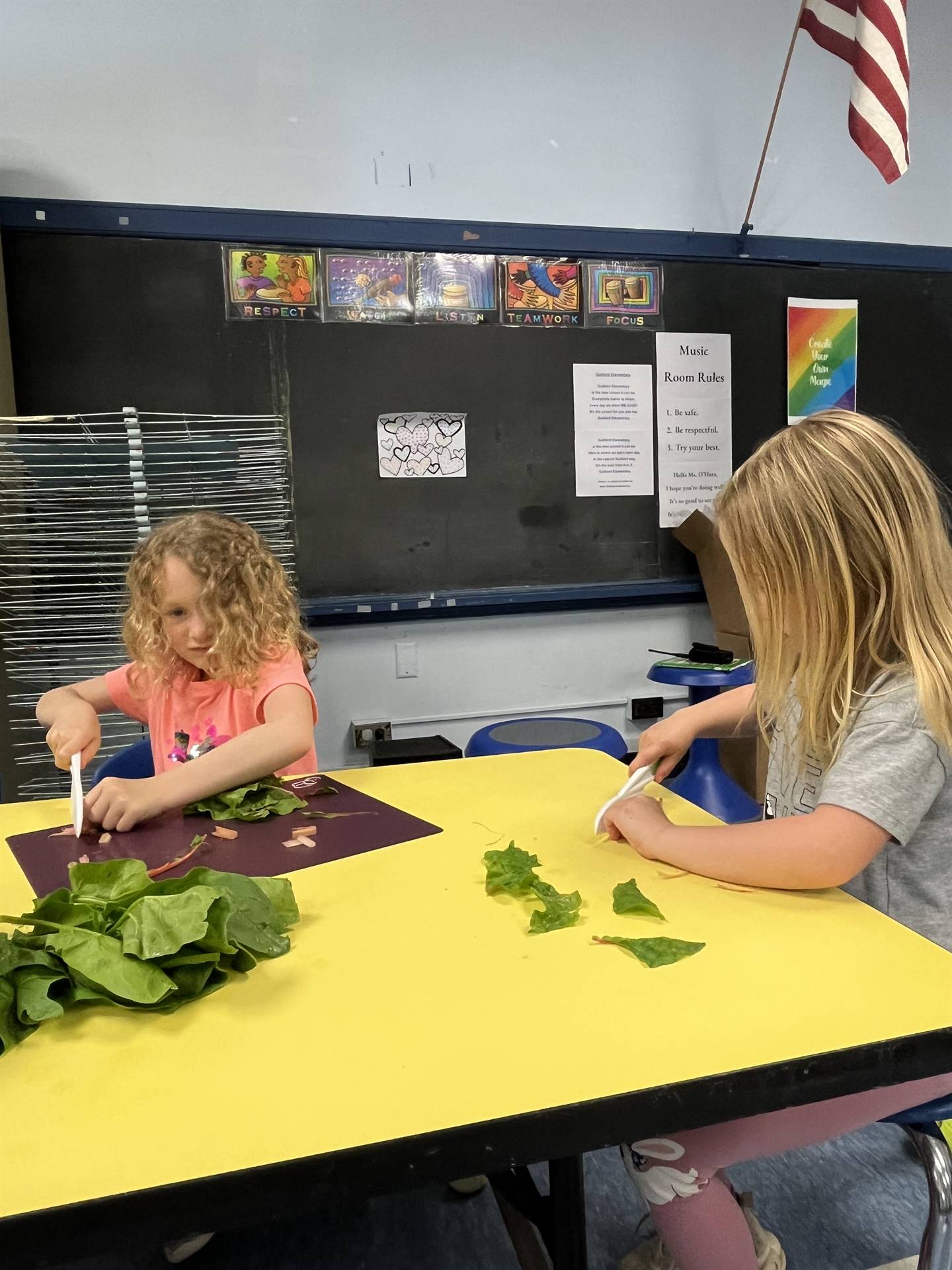 2 students at desk cutting greens.