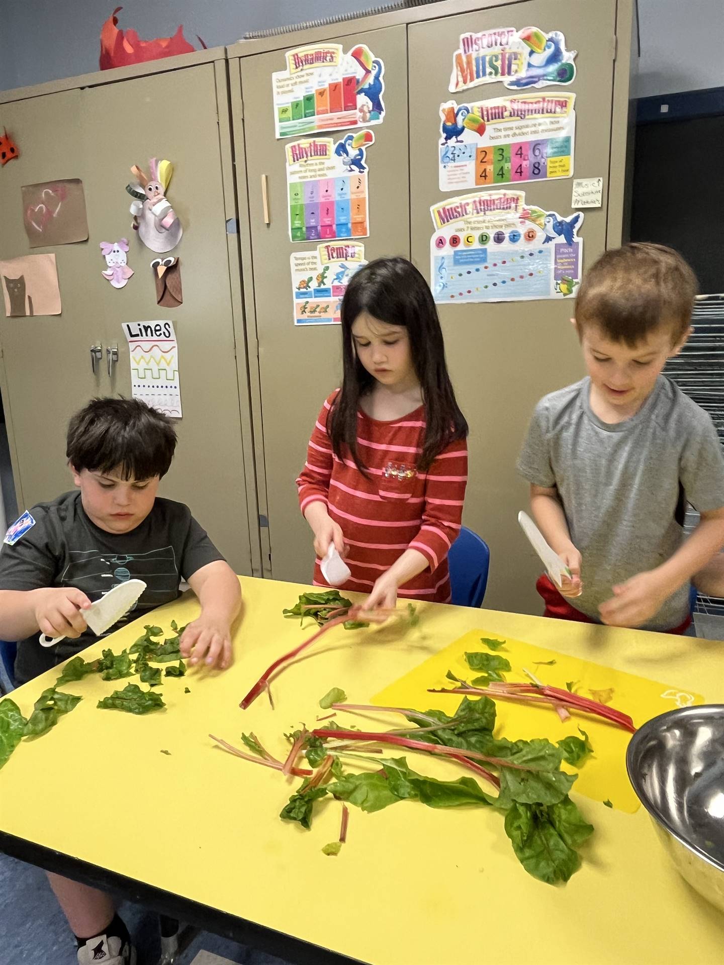 3 students at desk cutting greens.