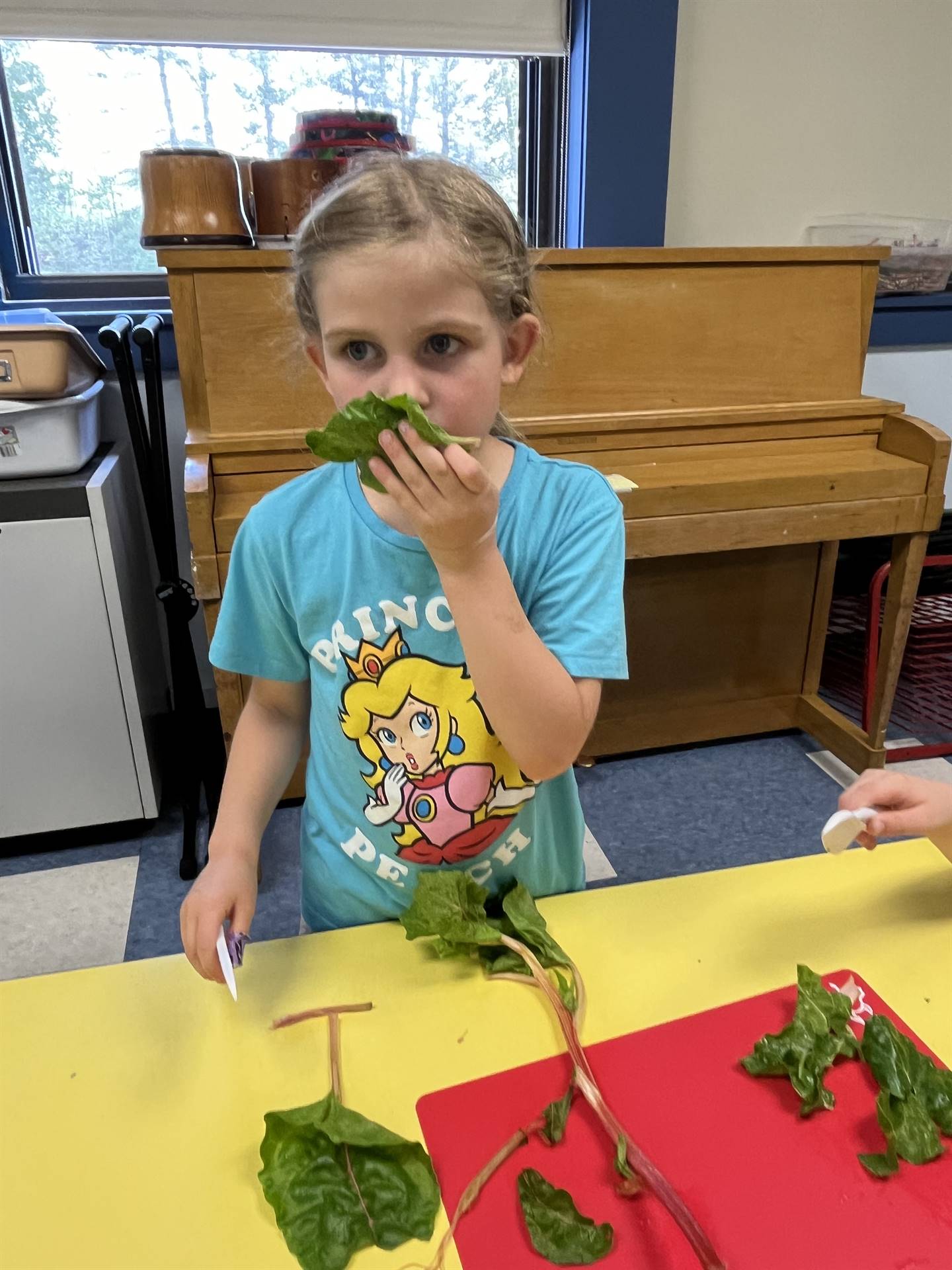 a student smelling spinach greens!