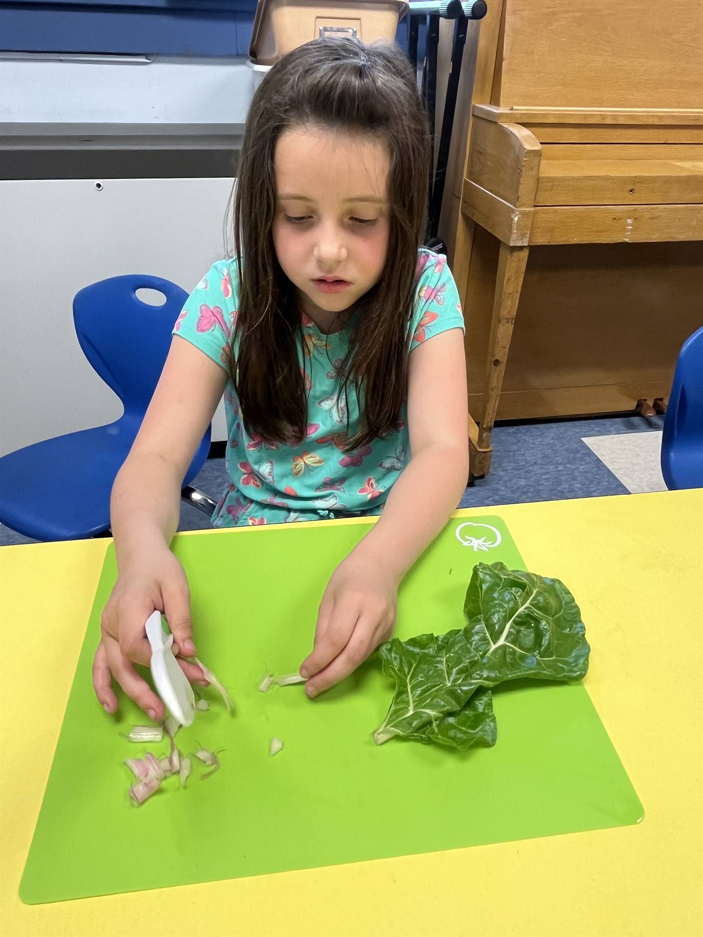 a student cutting up swiss chard greens.