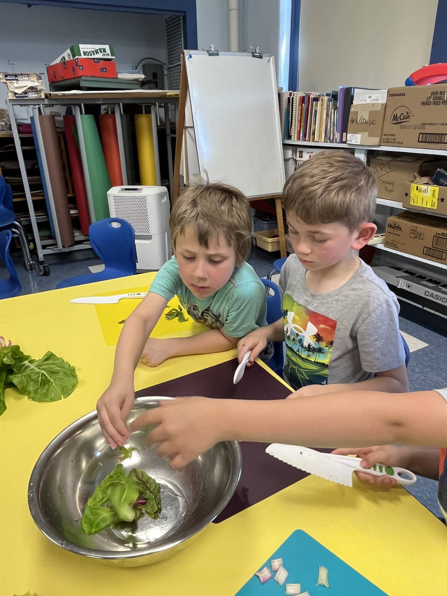 2 students cutting up swiss chard greens.