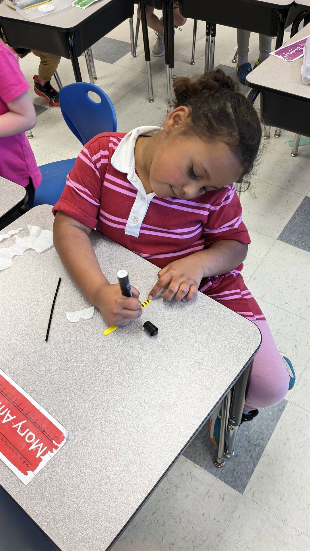 student sitting at desk coloring.