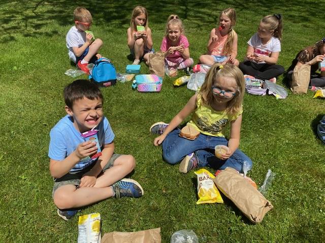 students sitting on grass eating lunch
