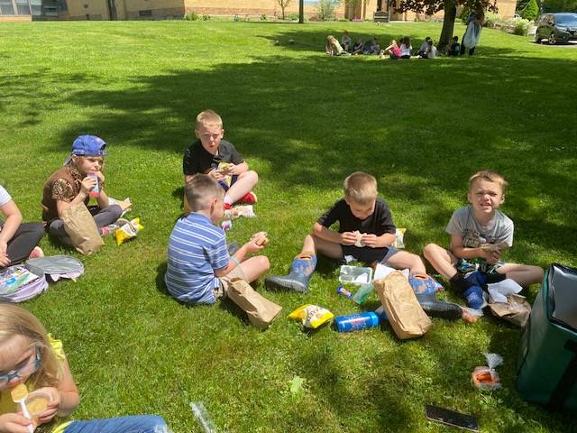 students sitting on grass eating lunch