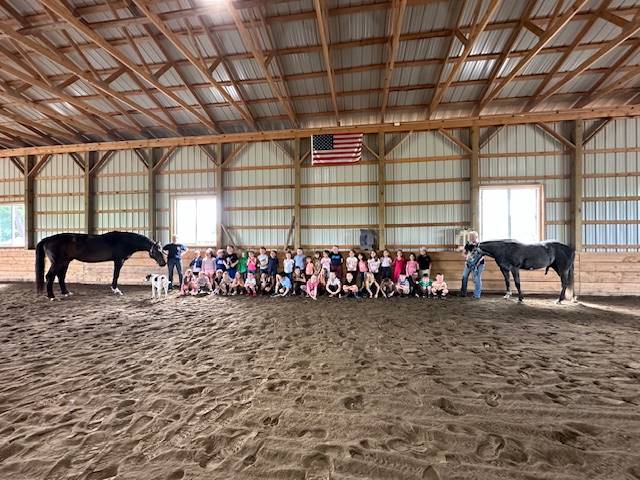 a group of students between 2 horses