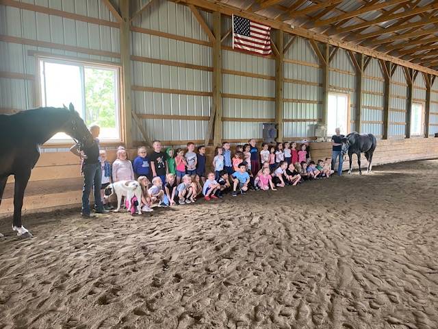 a group of students between 2 horses