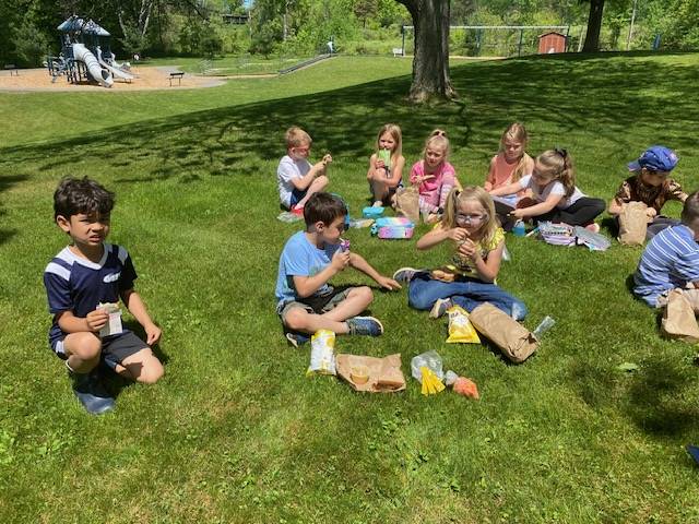 students sitting on grass eating lunch
