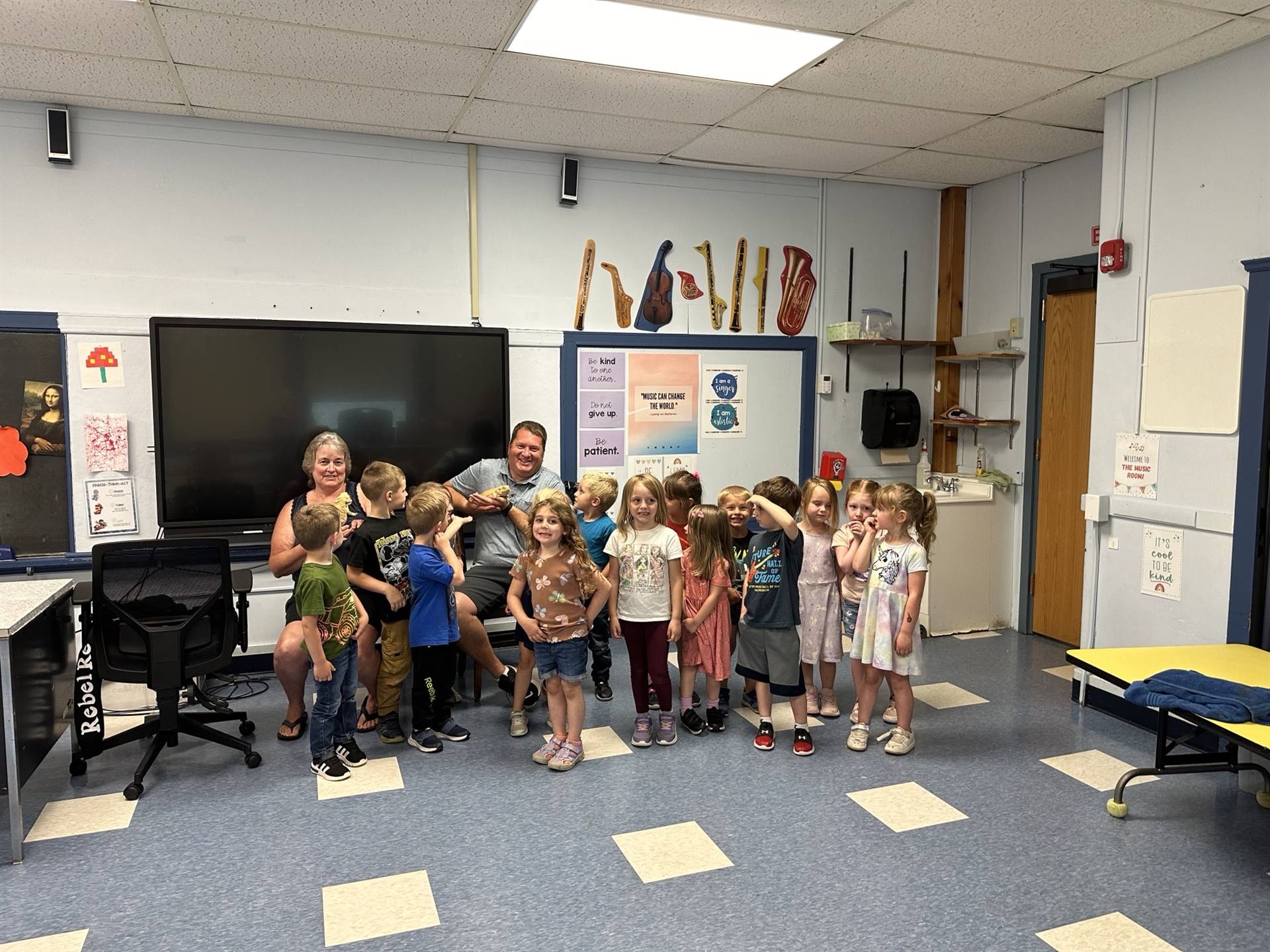 adult with a rainbow chameleon and class of kids.